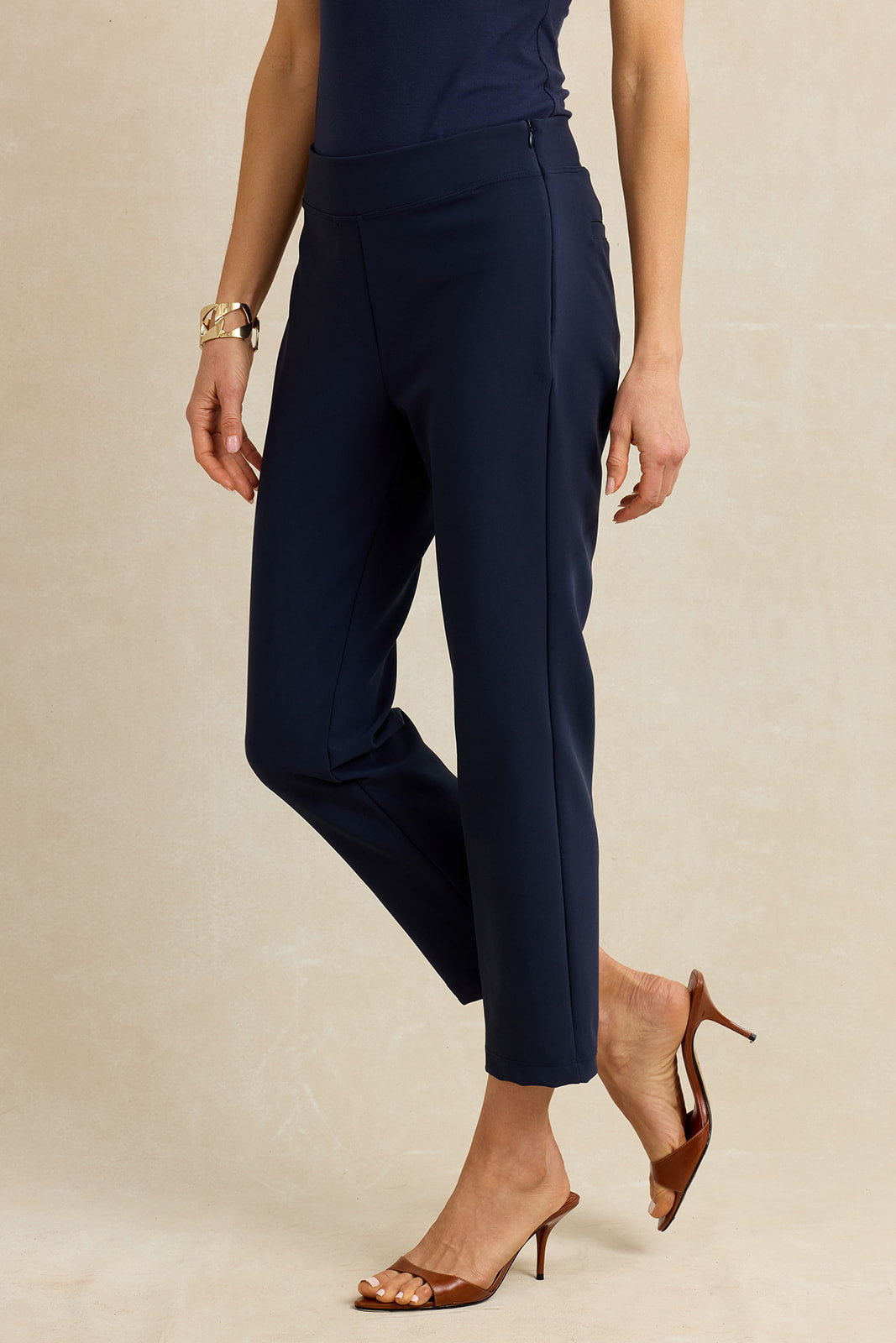 Navy blue pants worn by a person on a beige background