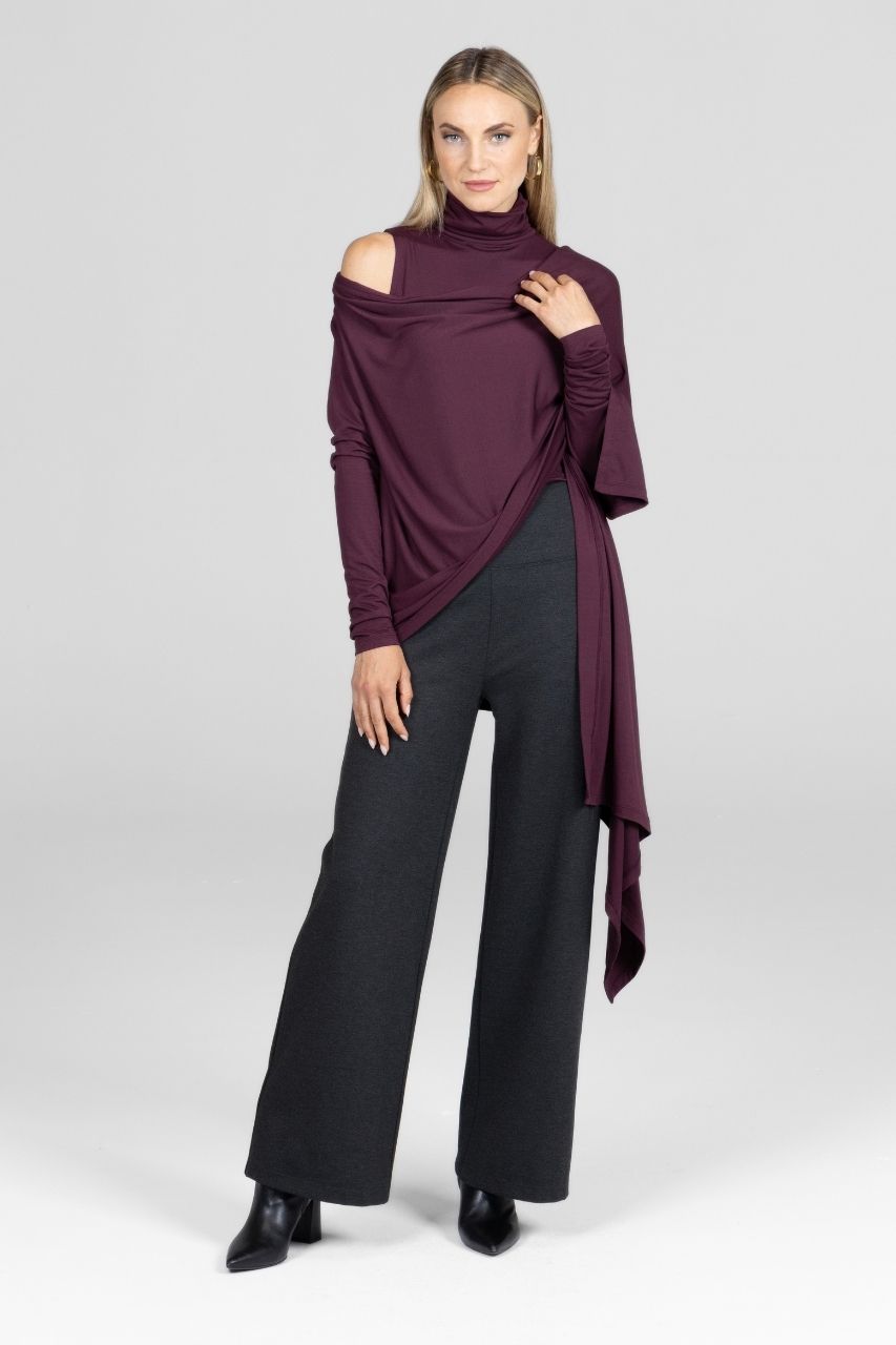 Woman wearing a burgundy off-shoulder top and black pants on a white background