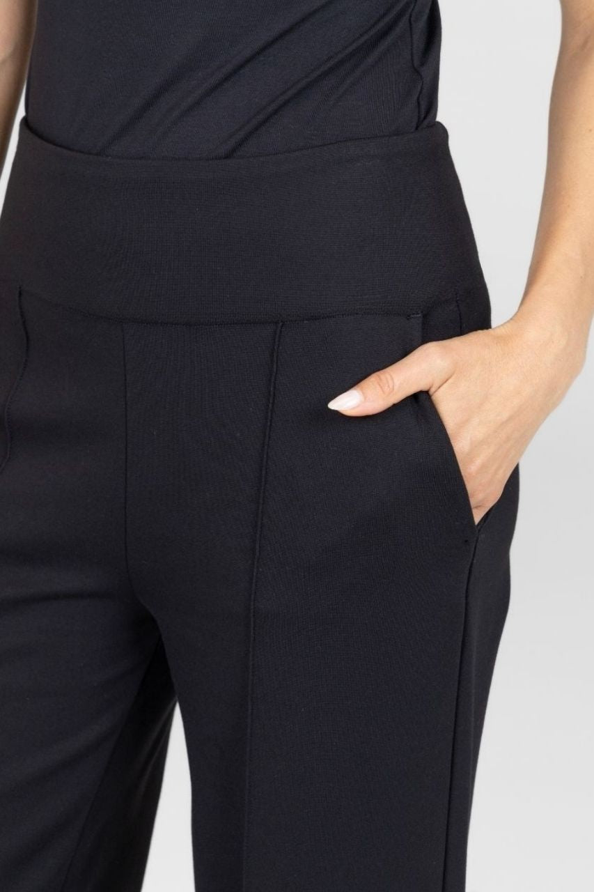 Black pants worn by a person on a light gray background