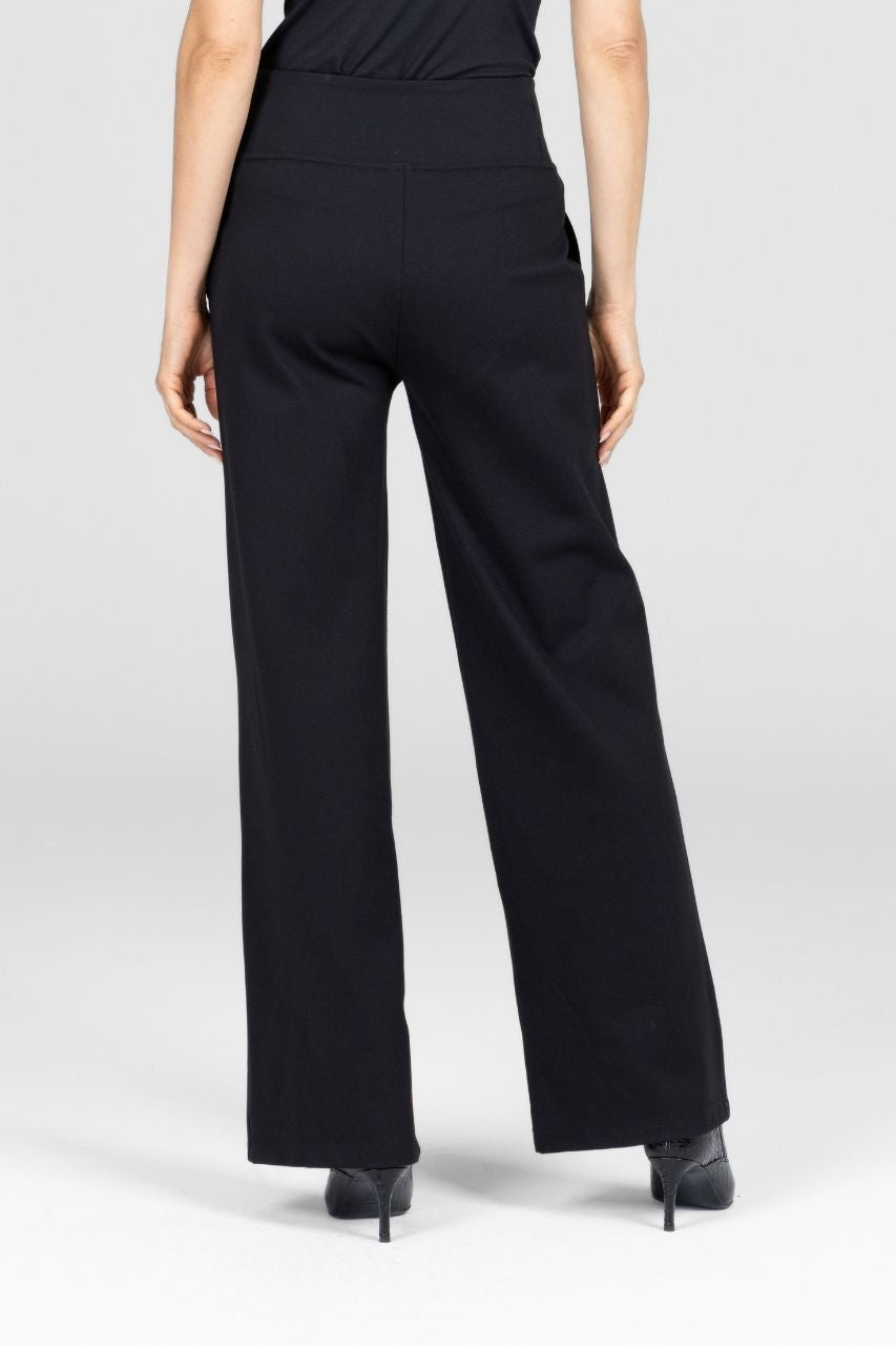 Person wearing black wide-leg pants on a white background