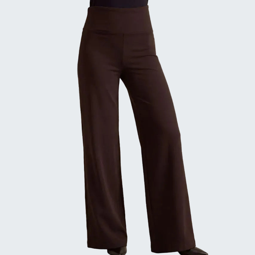 A person wearing dark brown wide-leg pants with a high waistband, shown from the waist down against a plain beige studio backdrop.