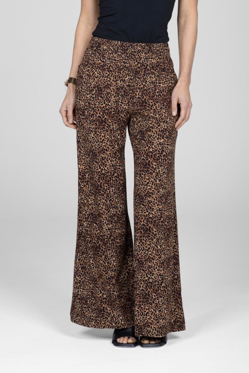 Leopard print pants worn by a person on a white background