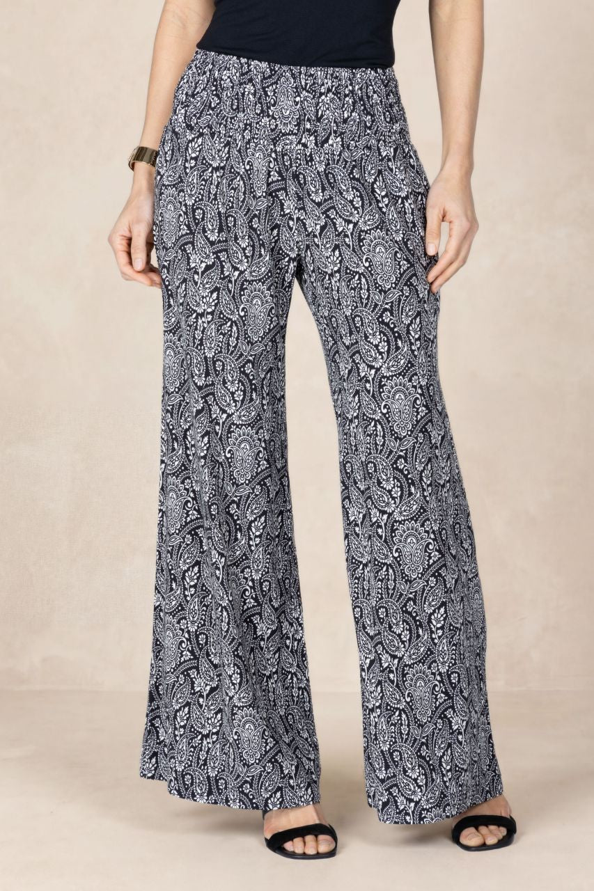 Person wearing a pair of patterned pants on a beige background