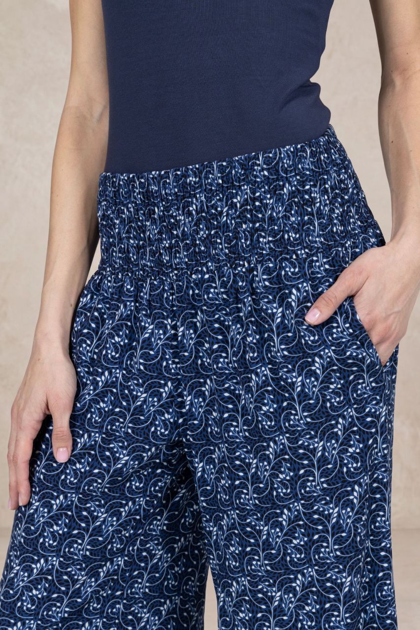 Navy blue patterned pants worn by a person on a beige background