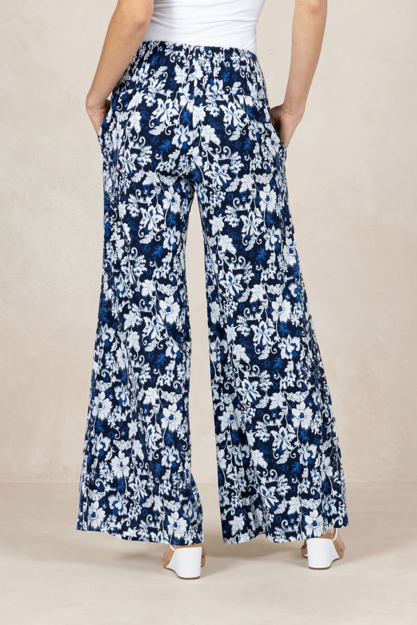 Person wearing blue floral wide-leg pants on a beige background