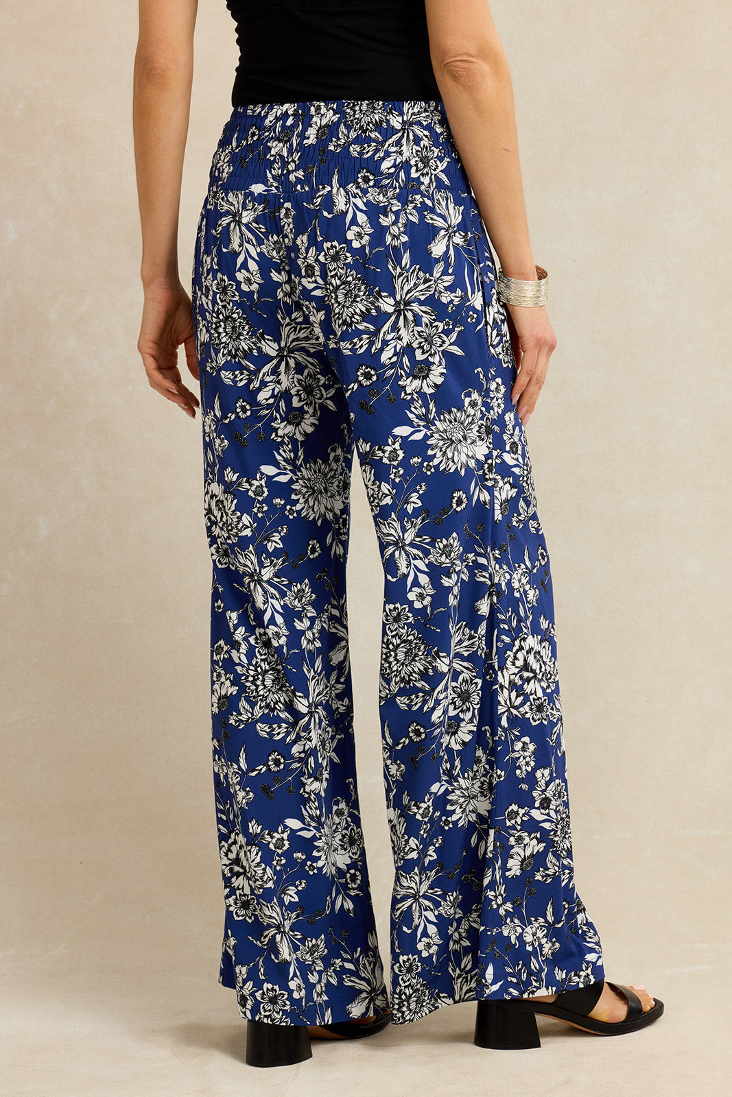 Person wearing blue floral pants on a beige background