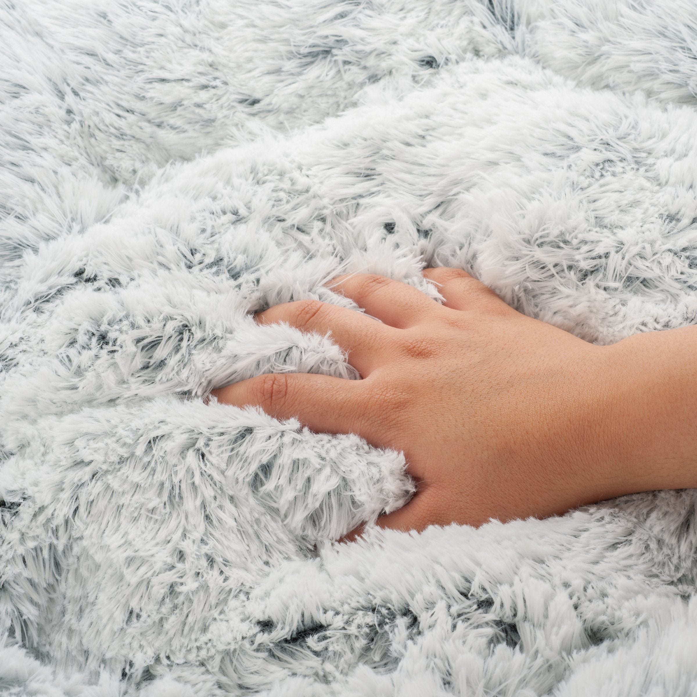Hand resting on a fluffy white surface