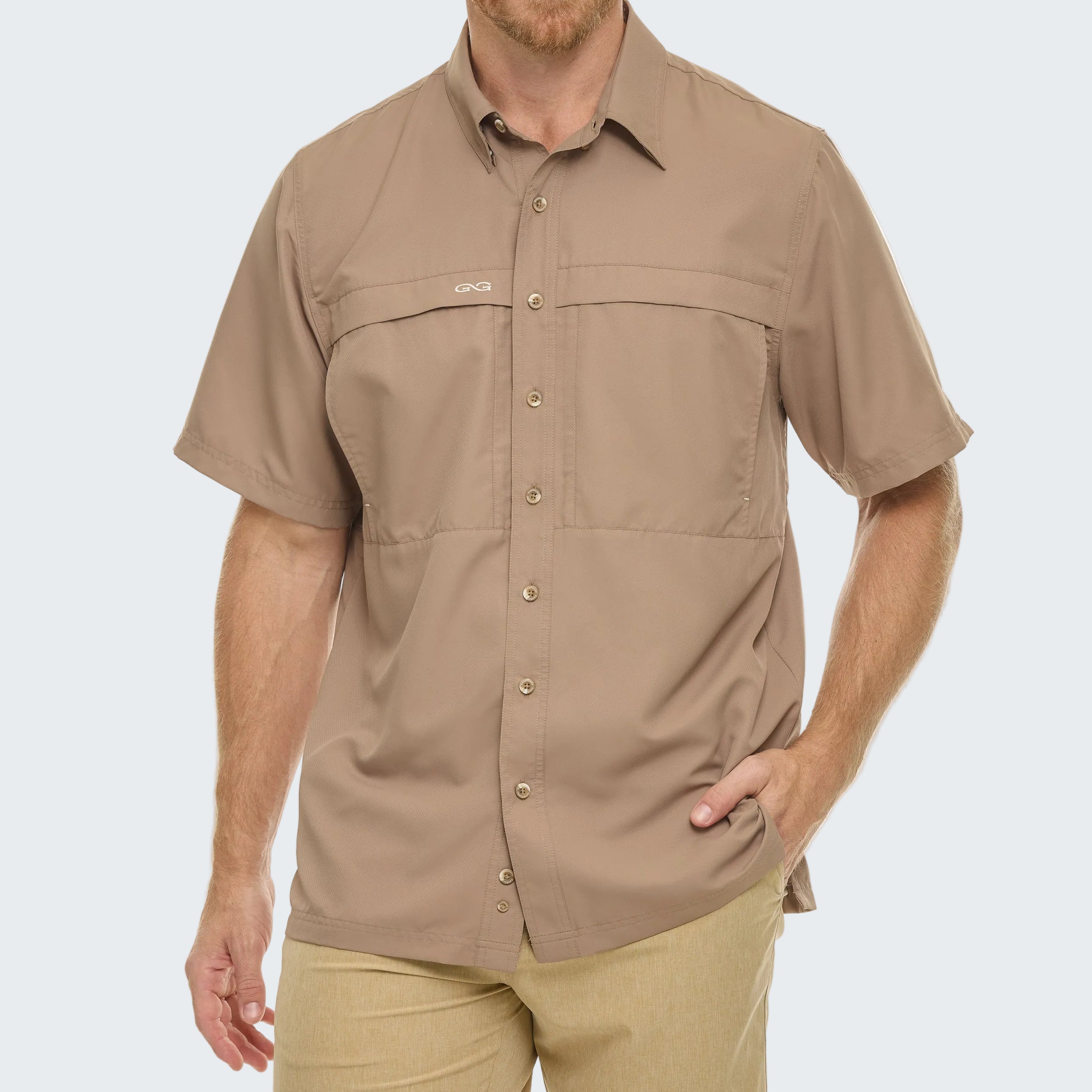 Man wearing a beige short-sleeve shirt on a white background