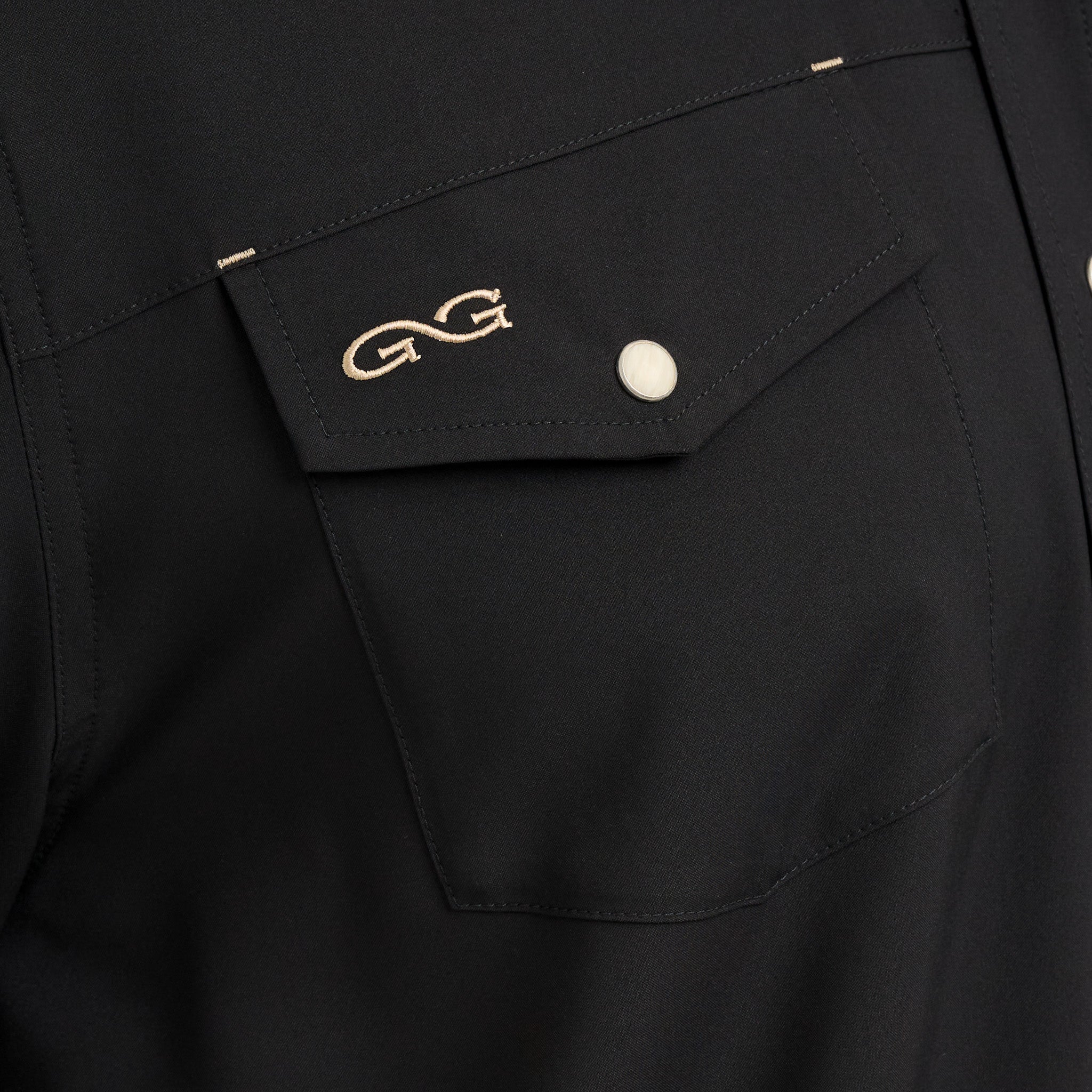 Black shirt pocket with gold embroidery and a white button