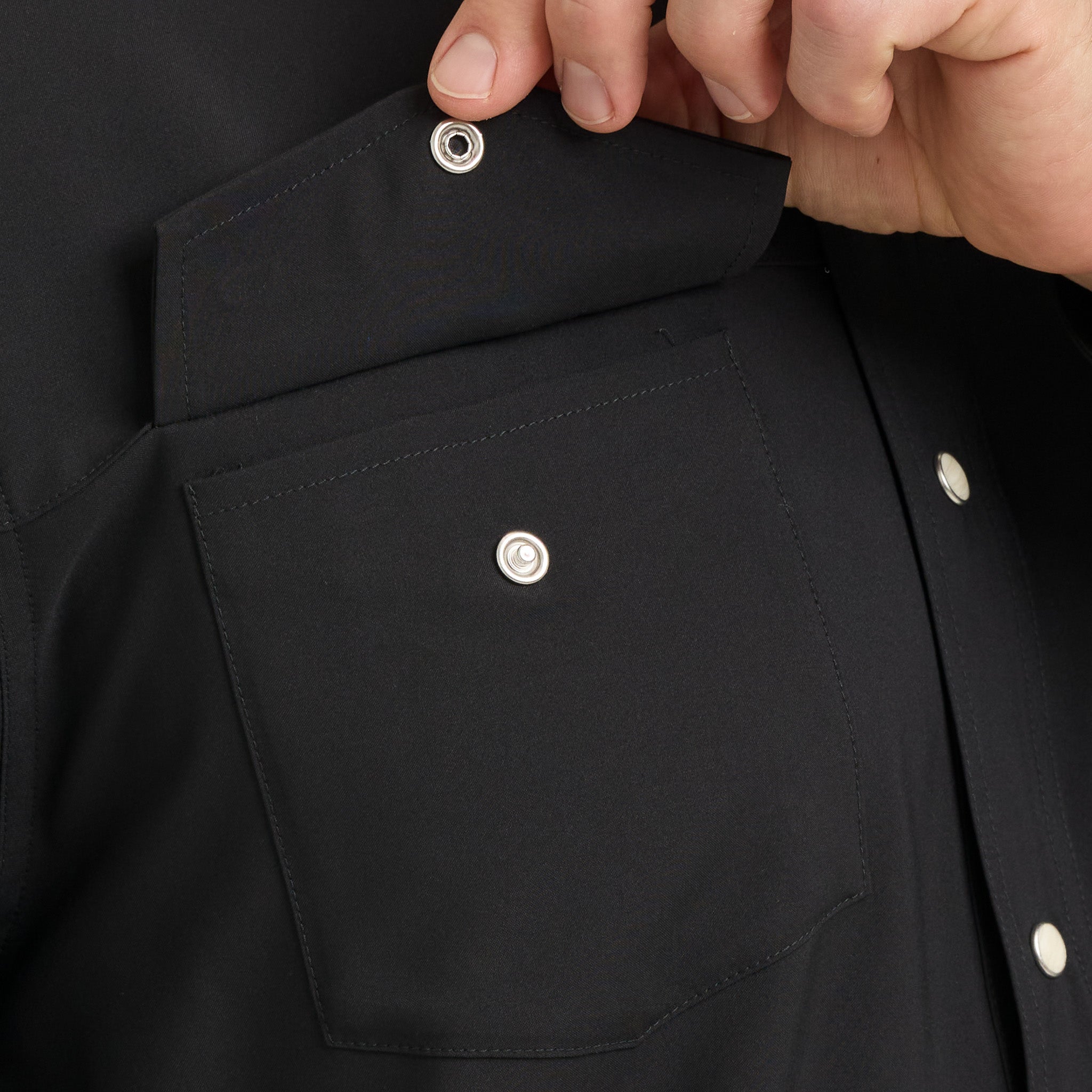 Close-up of a black shirt with buttons being adjusted