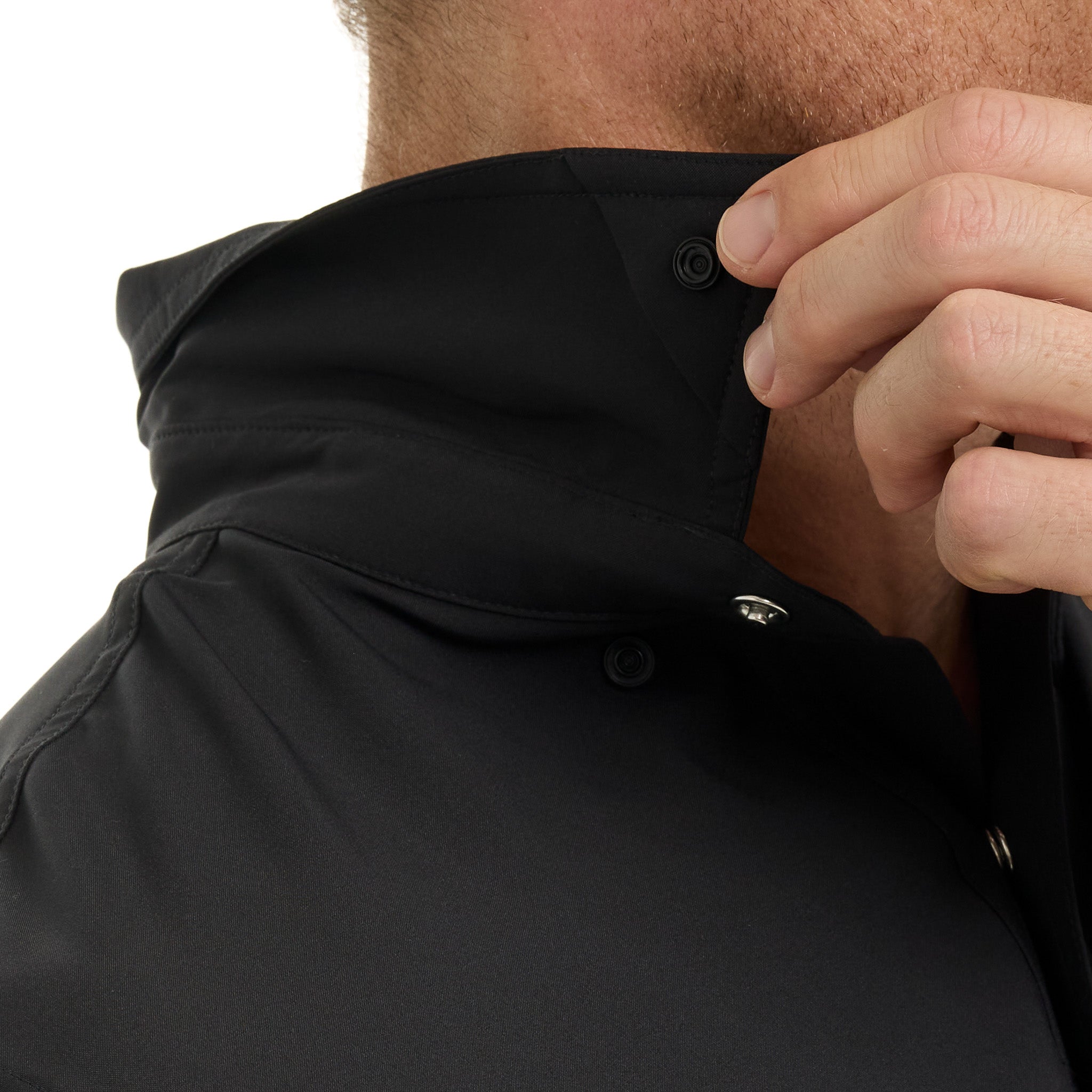 Close-up of a person adjusting the hood of a black jacket.