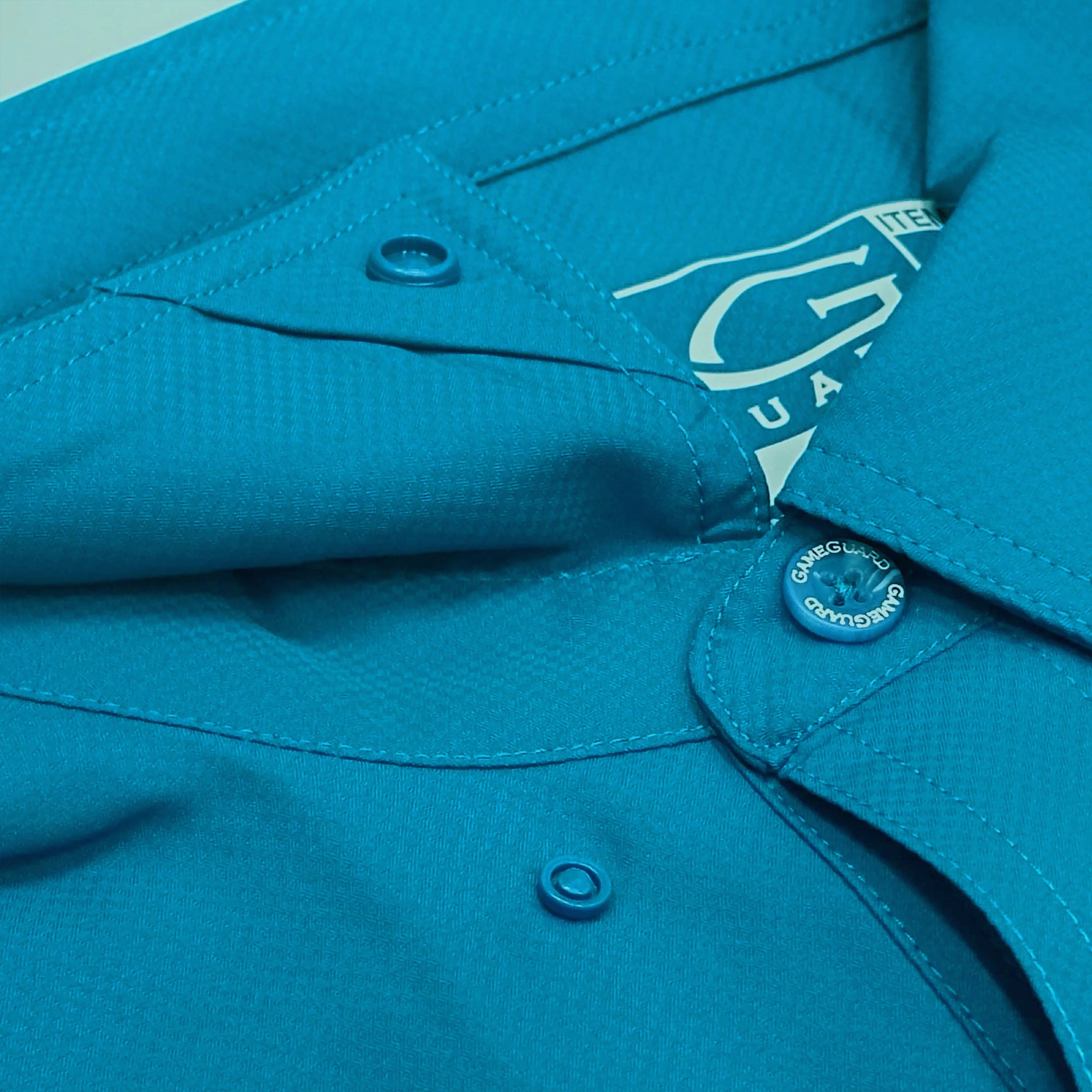 Close-up of a blue shirt with a brand label on the collar.