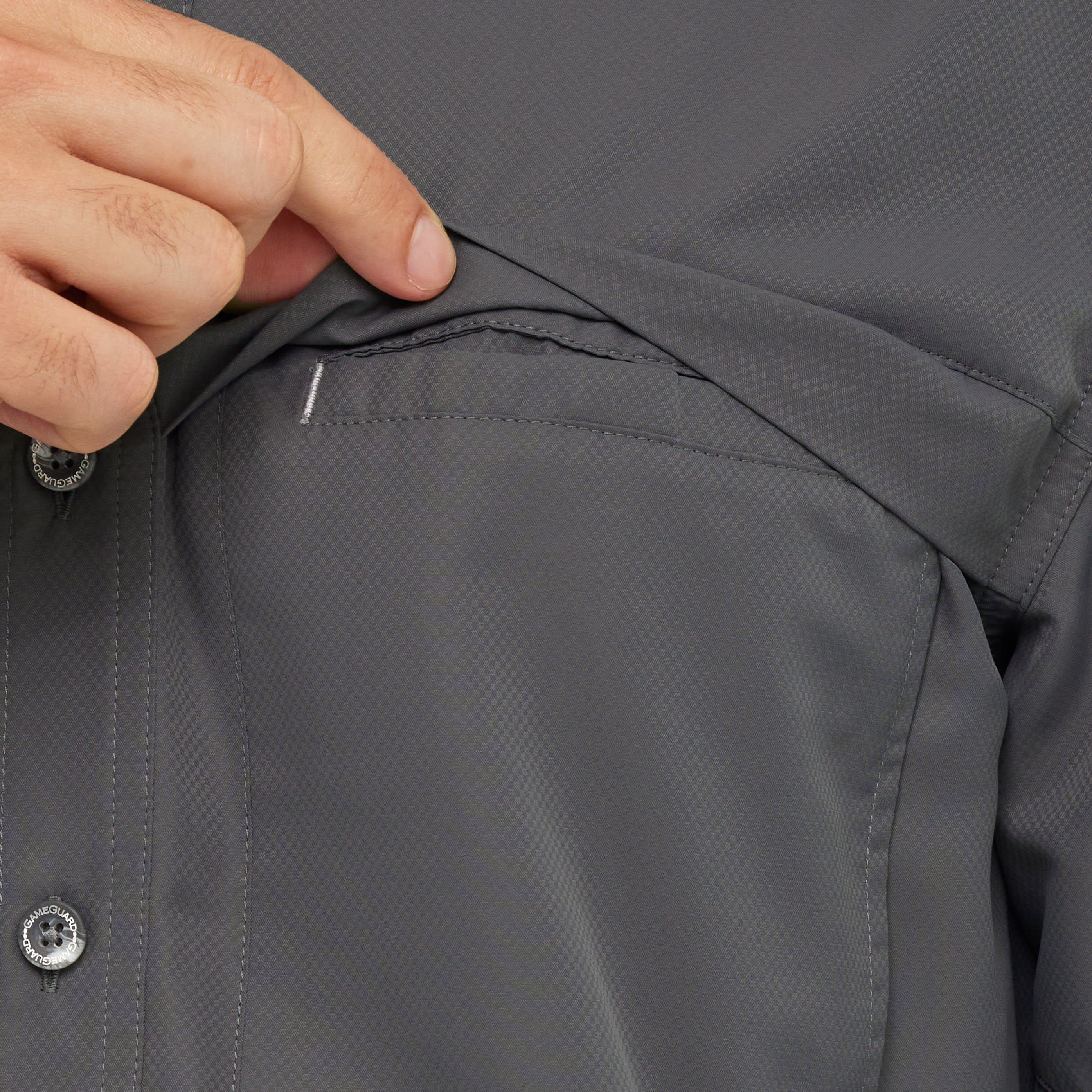 Close-up of a person adjusting the hood of a dark gray jacket.