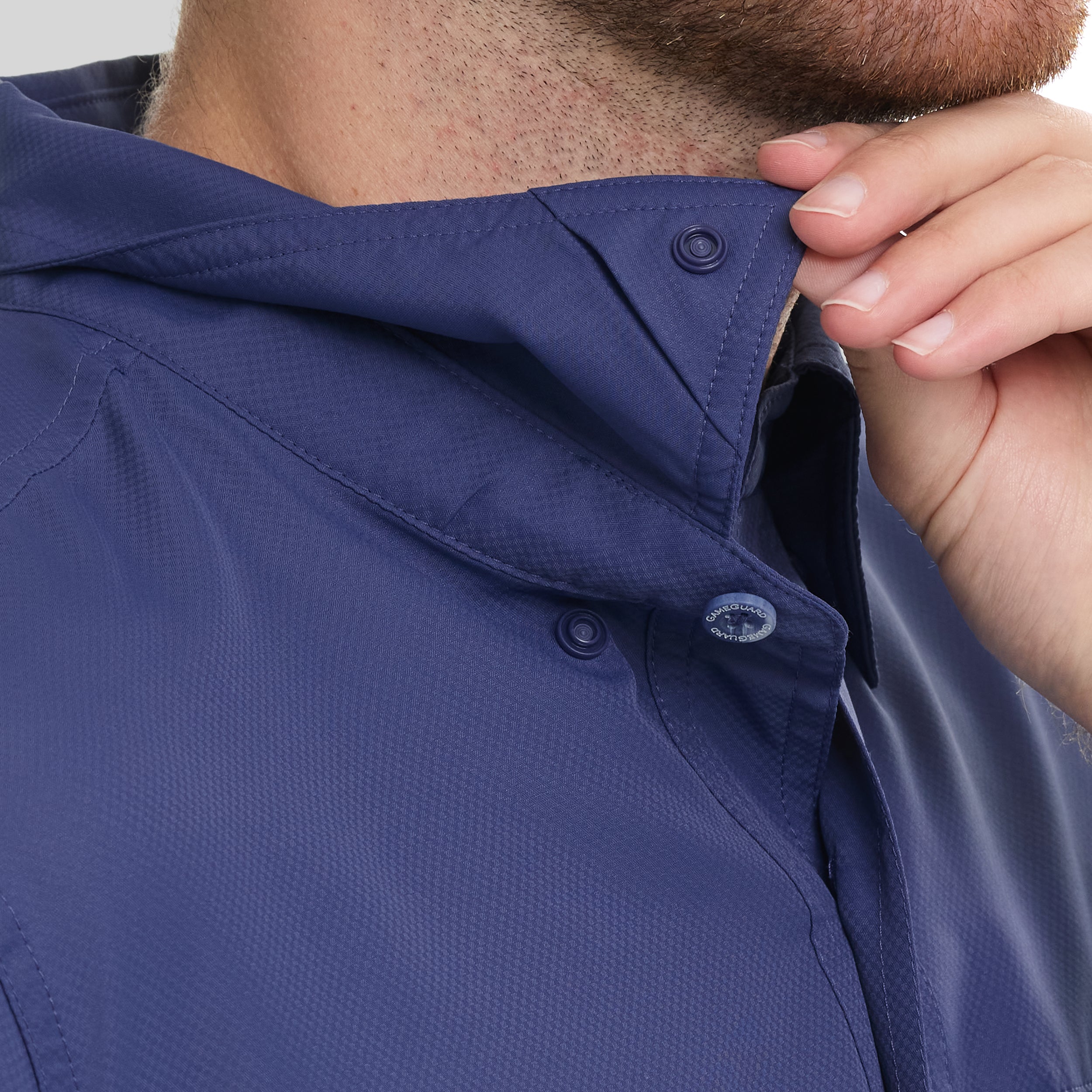 Close-up of a person adjusting the collar of a blue jacket.