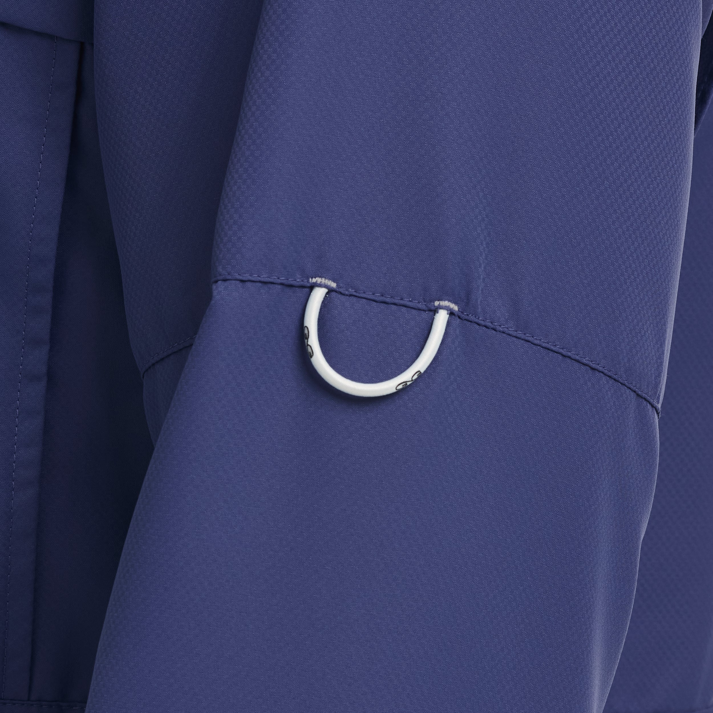 Close-up of a blue garment with a white metal ring detail