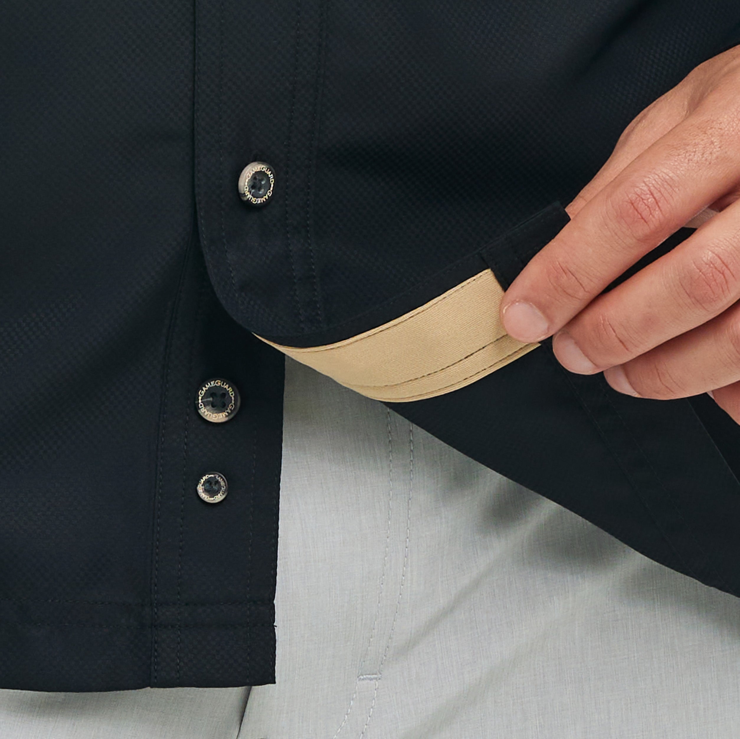 Close-up of a person adjusting the collar of a dark jacket with beige lining.