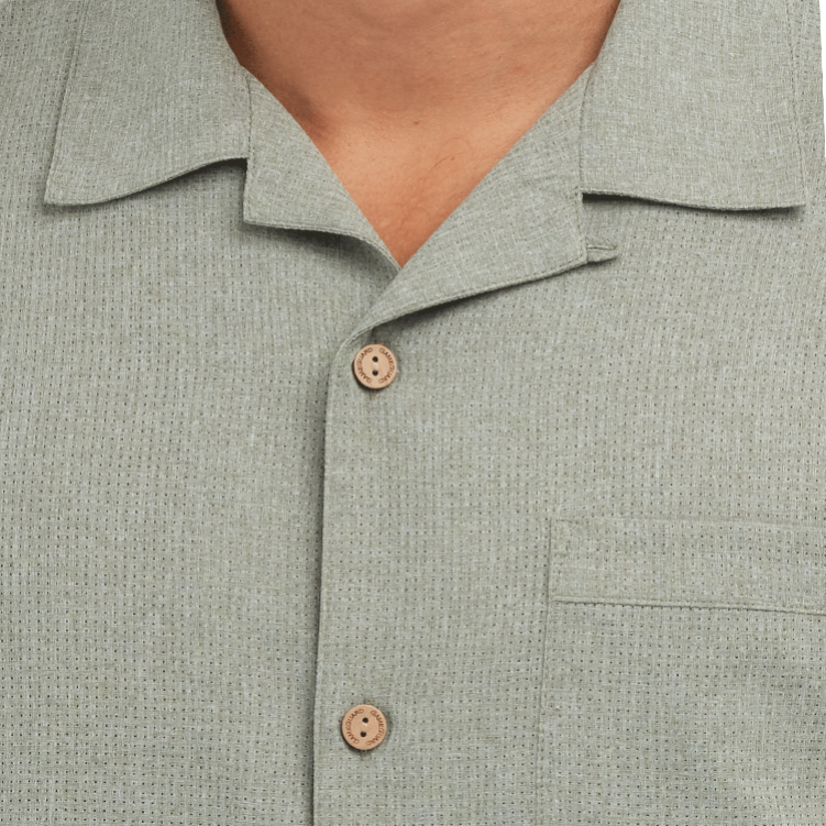Close-up of a light gray textured shirt with buttons on a white background
