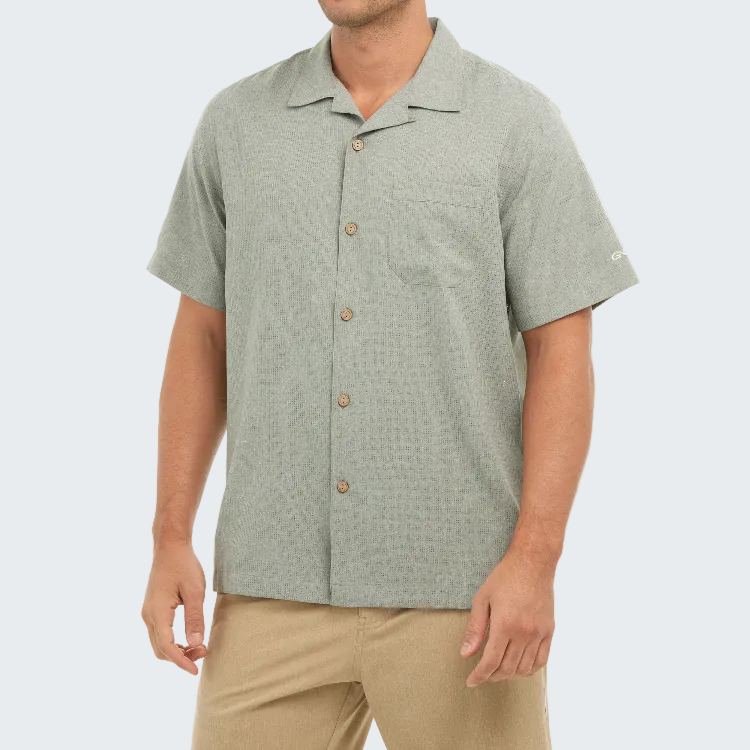 Man wearing a light green short-sleeve button-up shirt on a white background
