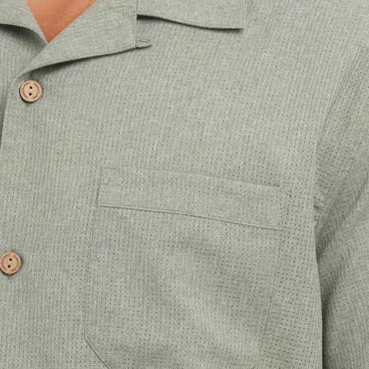Close-up of a green textured shirt with button details