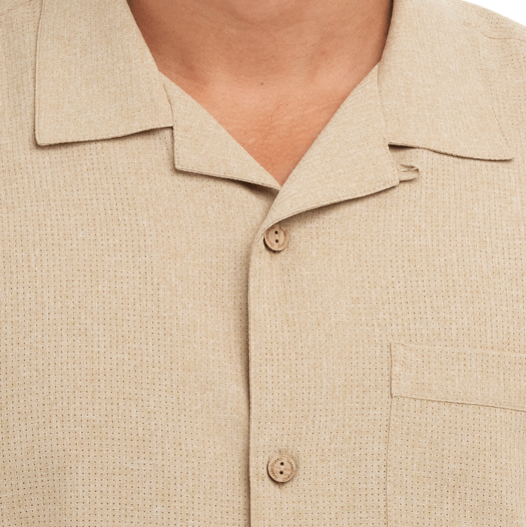Close-up of a beige textured shirt with collar and buttons.