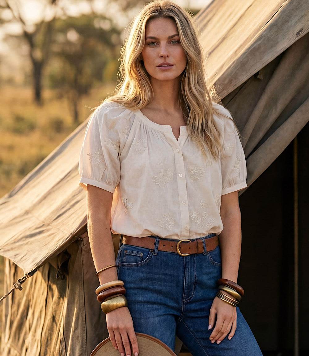 Woman standing in front of a wooden structure with a natural background