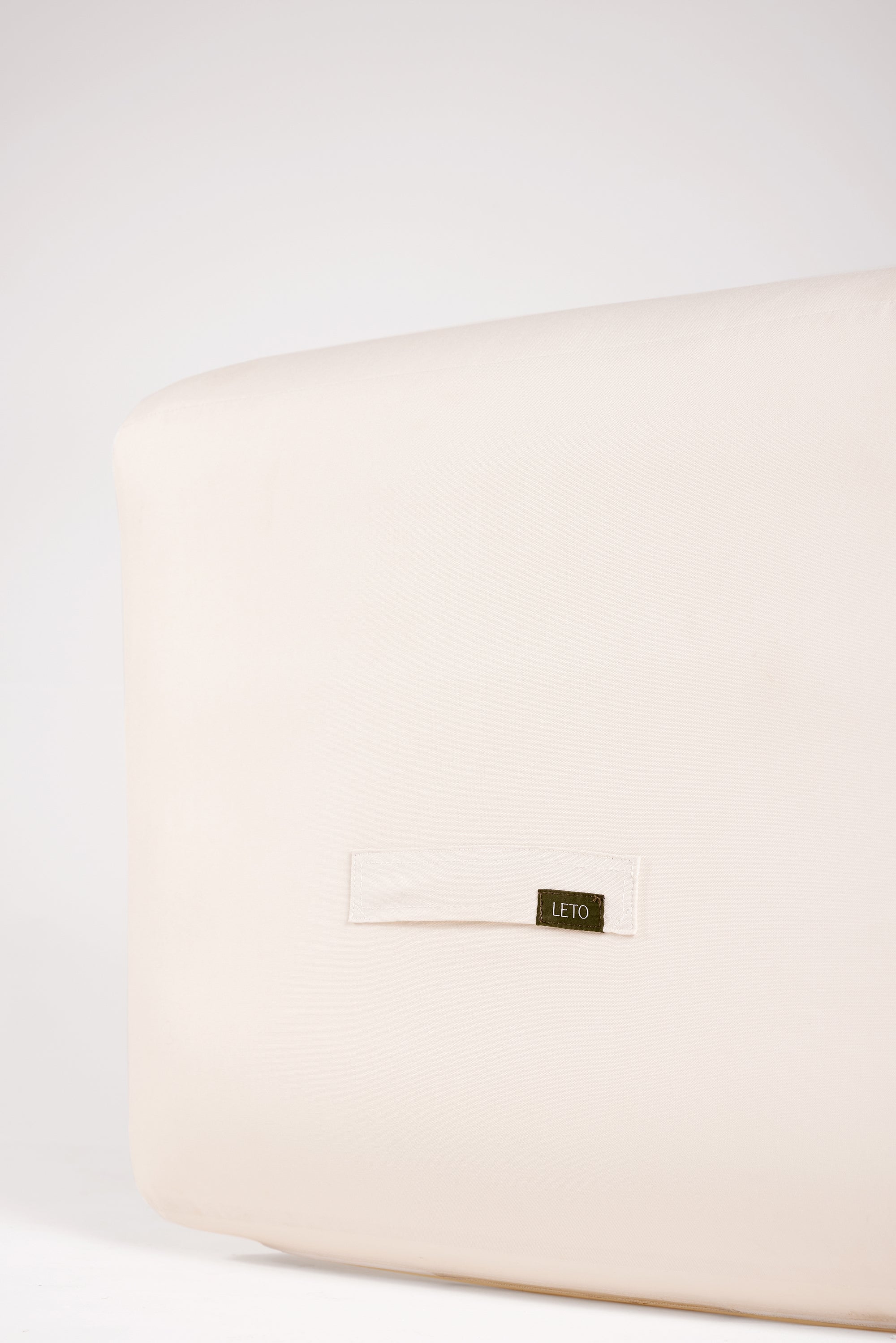 Beige pouch with a brand label on a white background