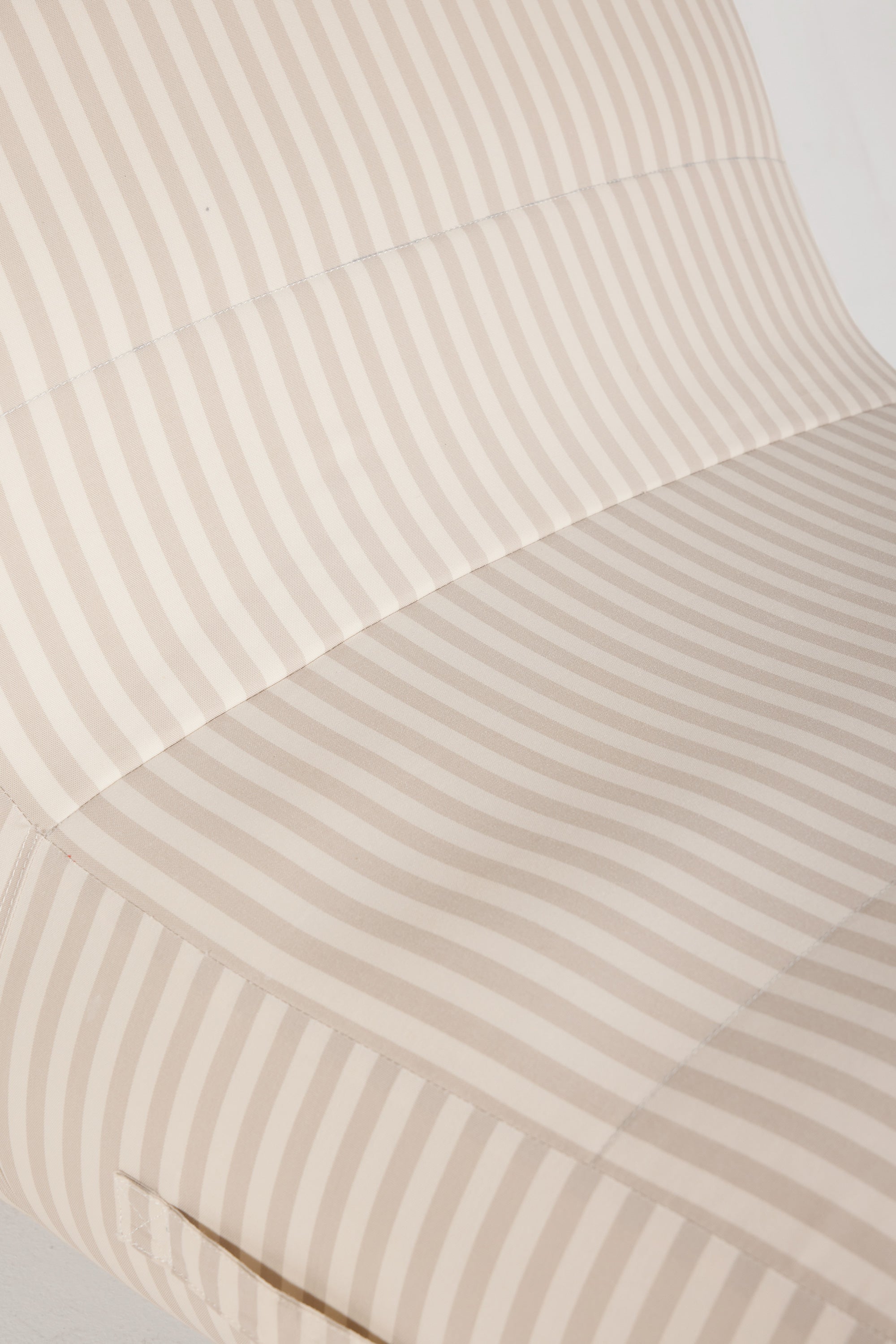 Close-up of a beige and white striped fabric with a subtle pattern.
