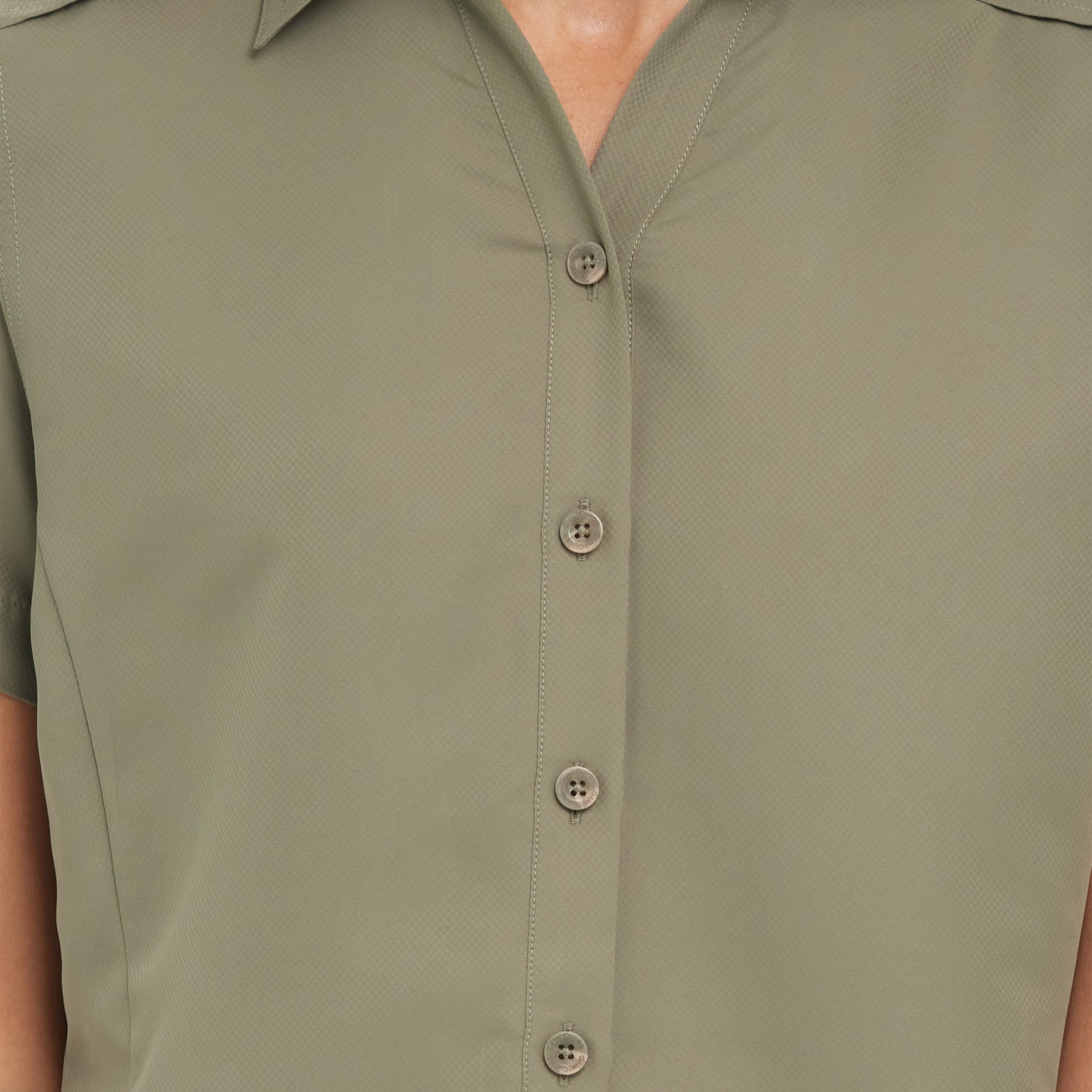Close-up of a green sleeveless shirt with buttons