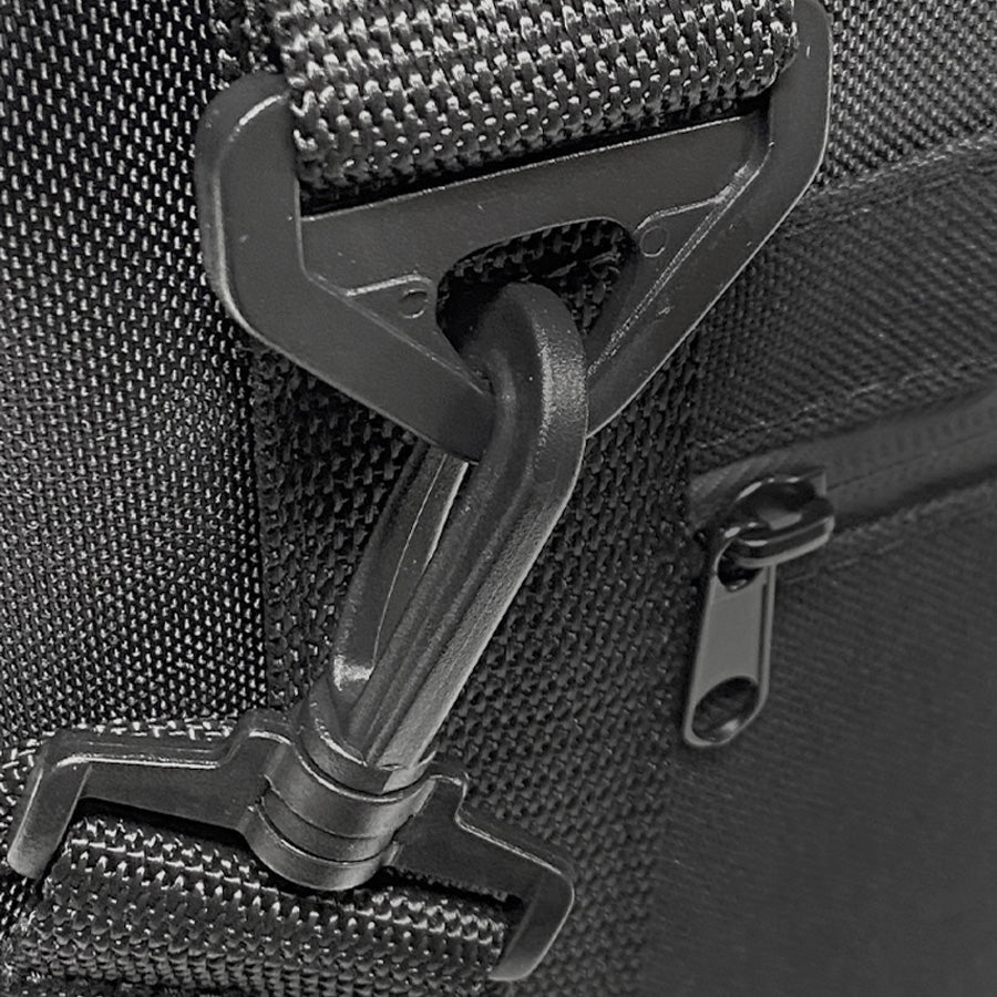 Close-up of a black bag with a zipper and buckle on a textured gray background