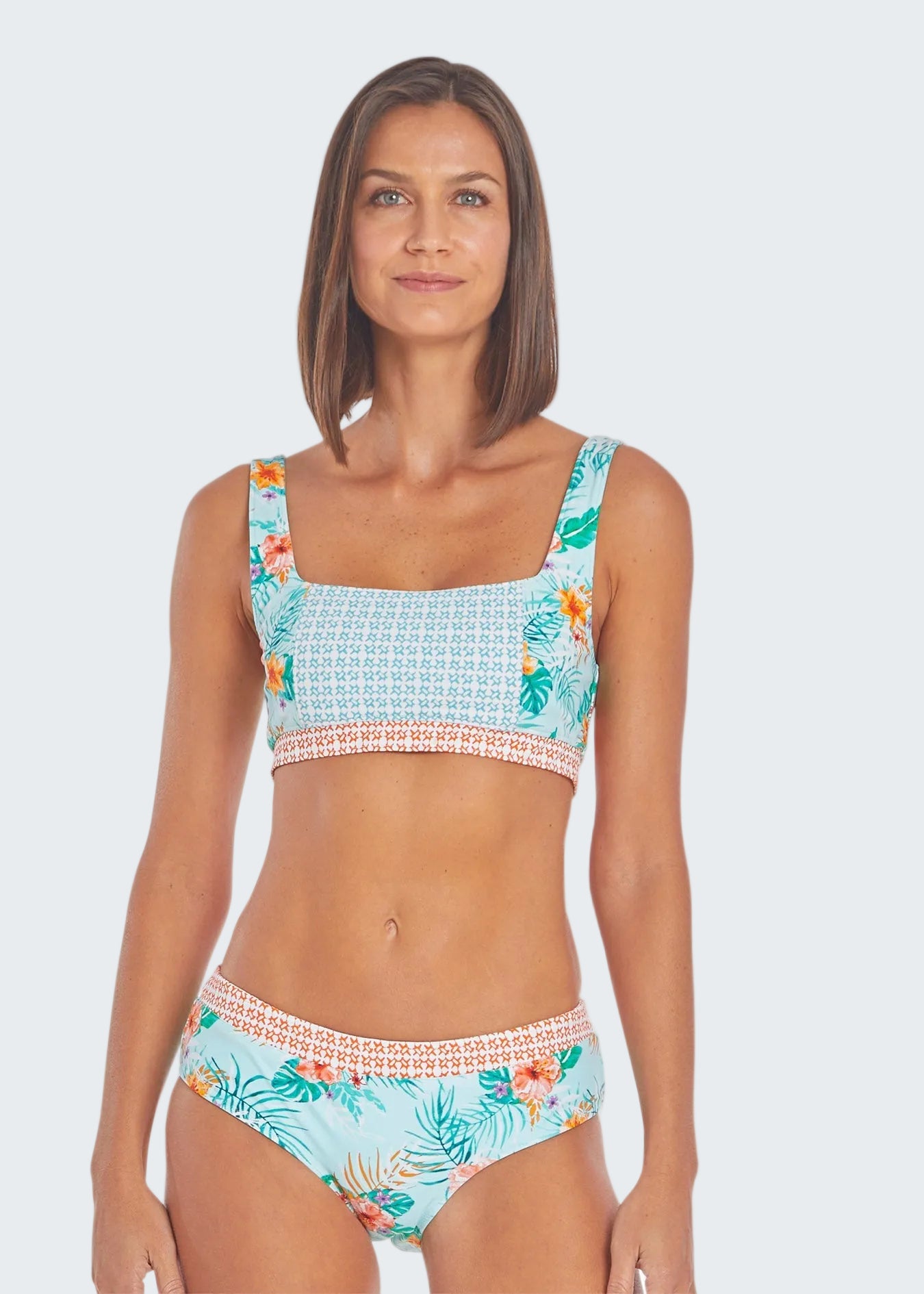 Woman wearing a tropical patterned bikini set on a white background