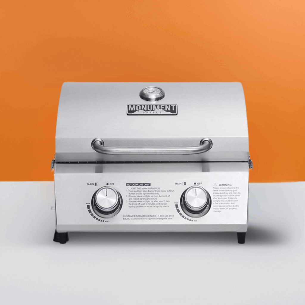 Stainless steel grill with 'Monument' branding on an orange and white background