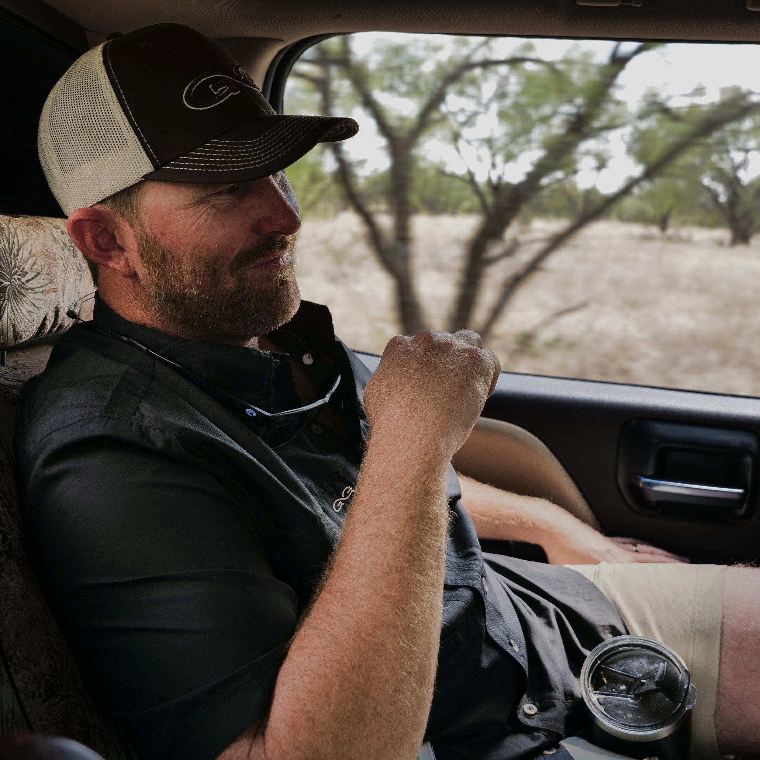 Man sitting in a car with a scenic outdoor view