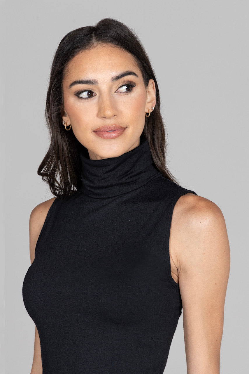 Woman wearing a black sleeveless top against a gray background