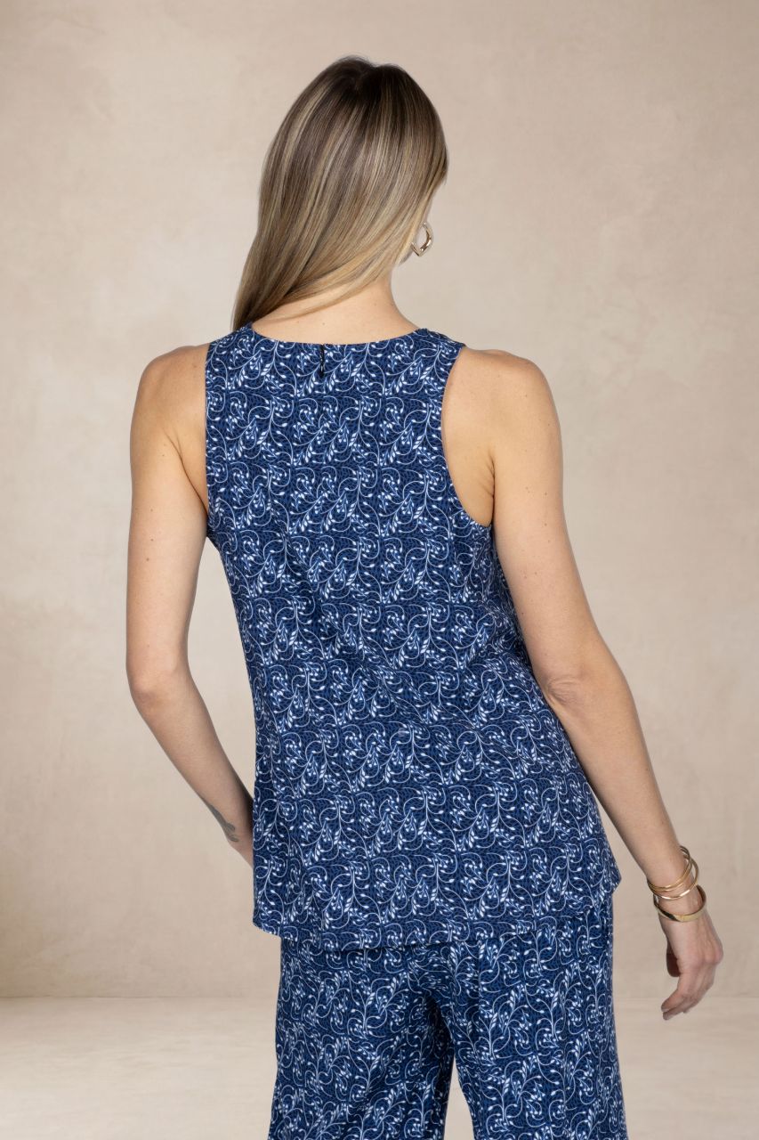 Woman wearing a blue floral jumpsuit against a beige background