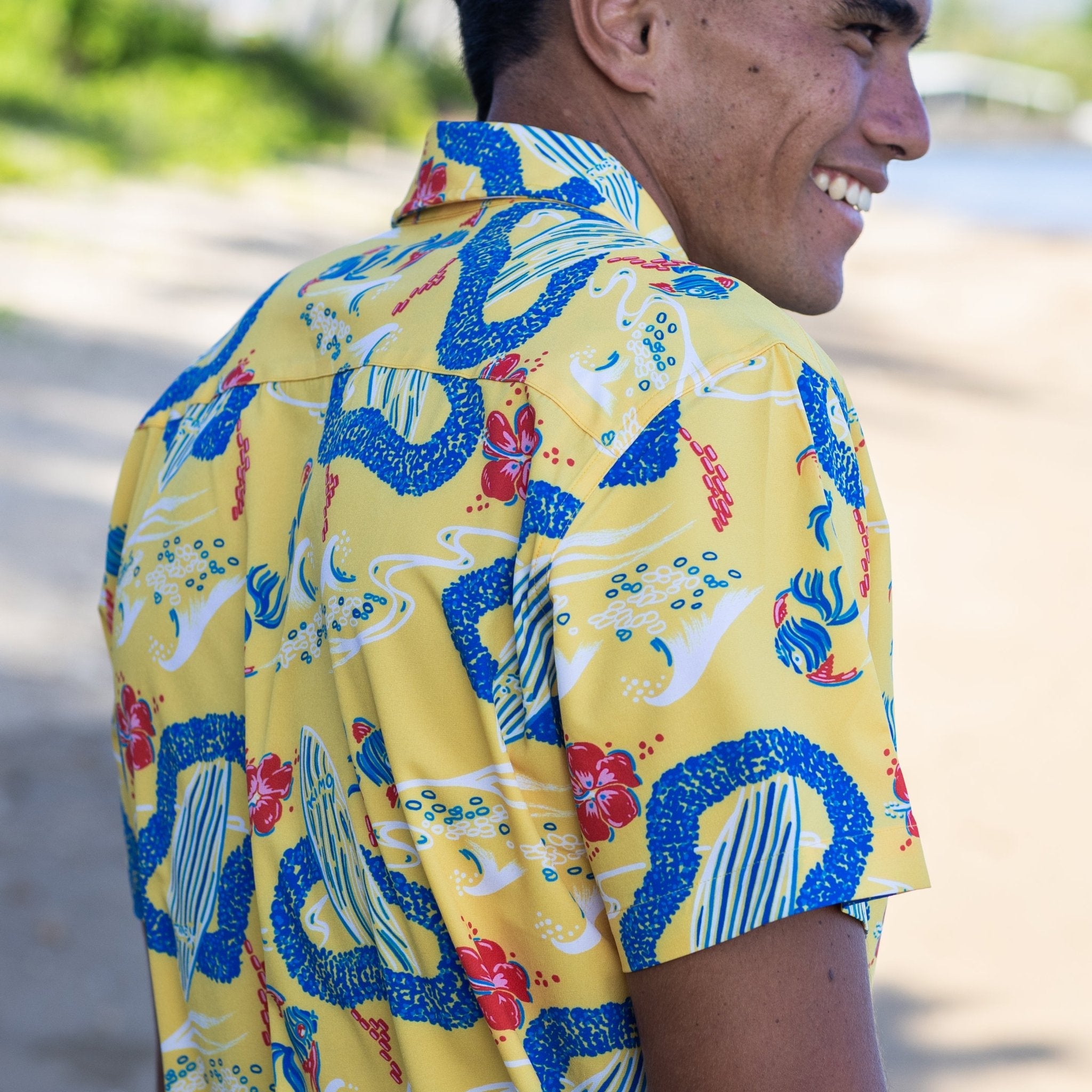Man wearing a colorful patterned shirt with a blurred natural background