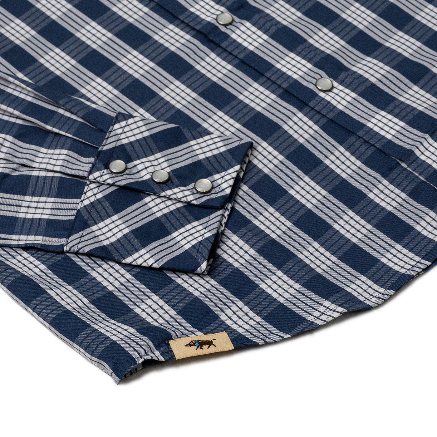 Close-up of a blue and white plaid shirt with a brand label on a white background