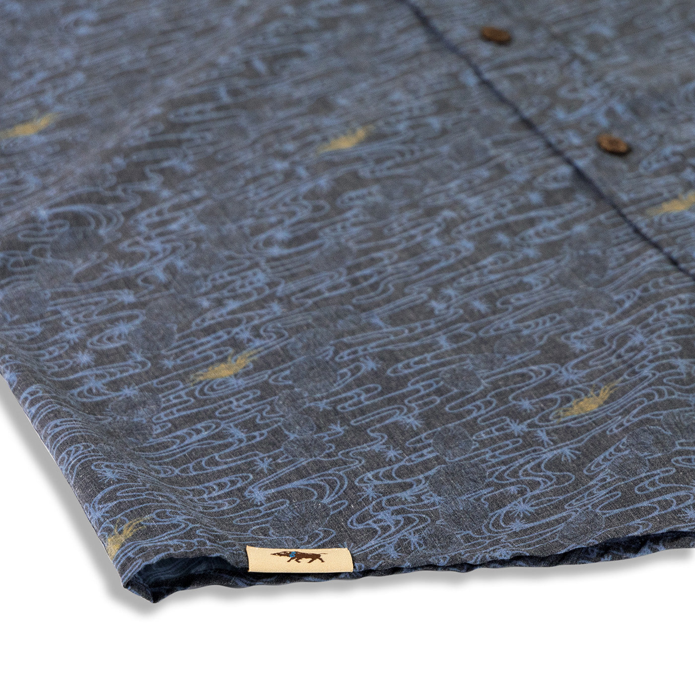 Close-up of a patterned fabric with a brand label on a gray background