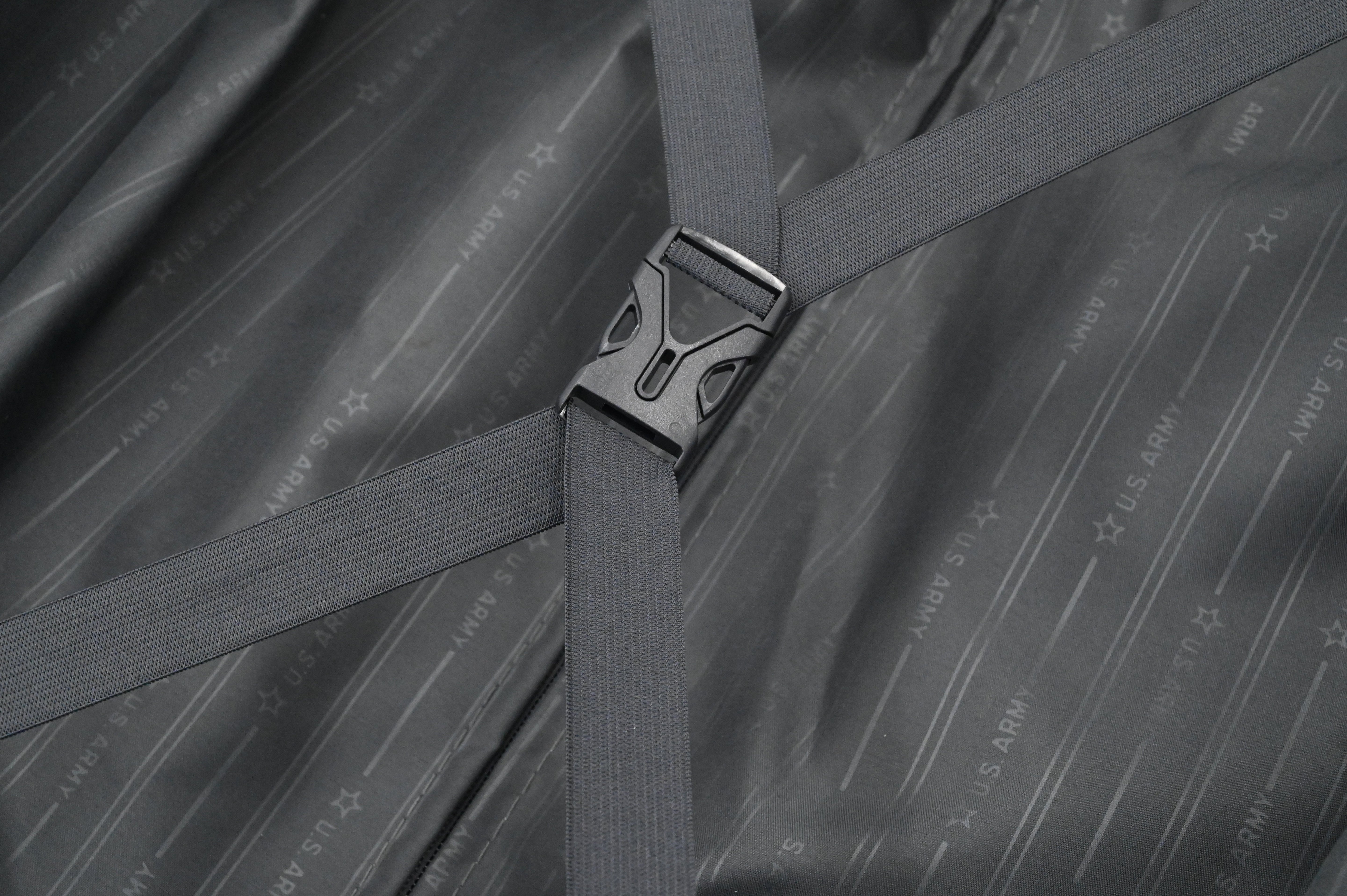 Close-up of a gray strap with a buckle on a textured gray background