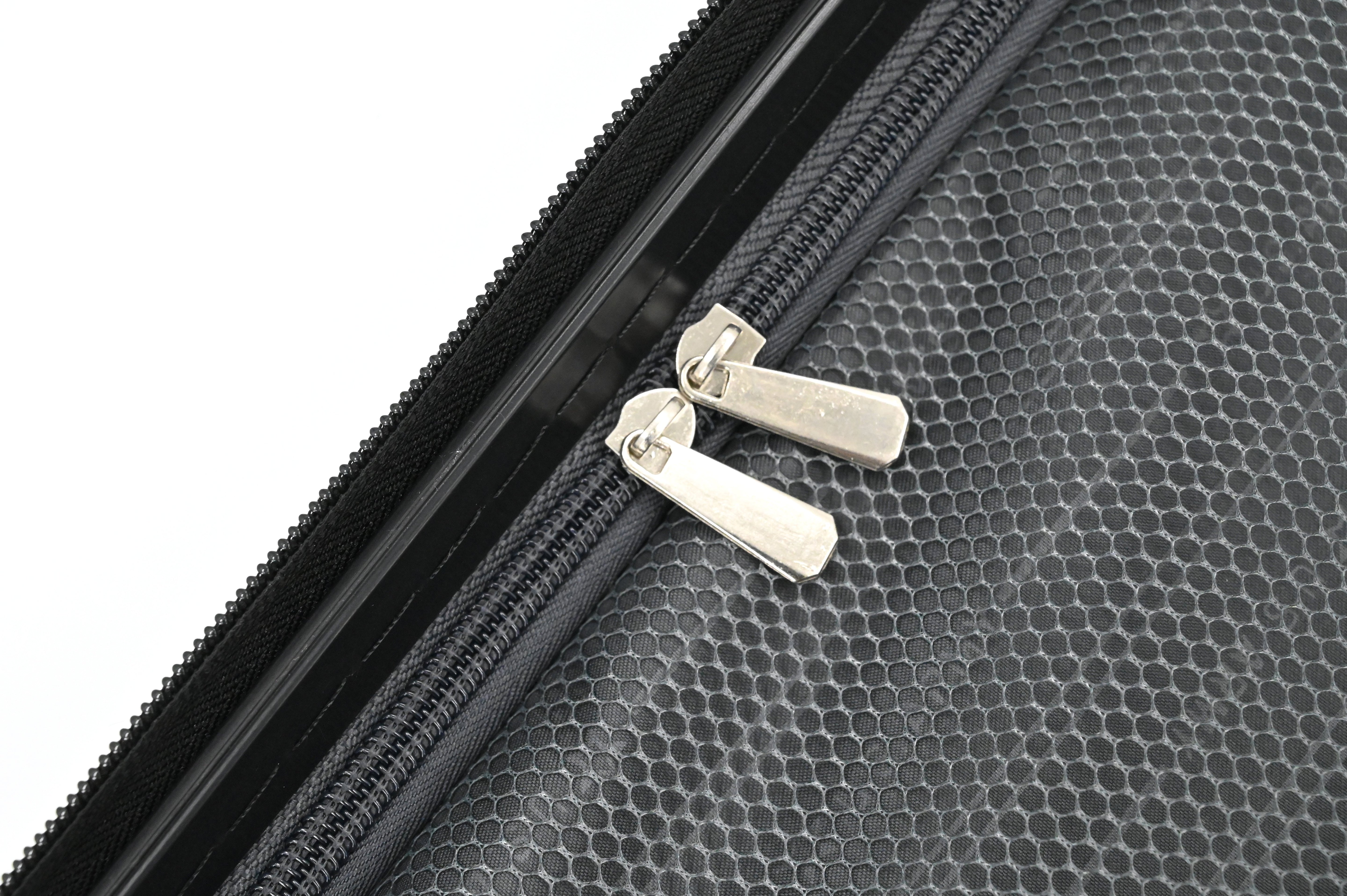 Close-up of a black textured surface with a zipper and silver zippers.