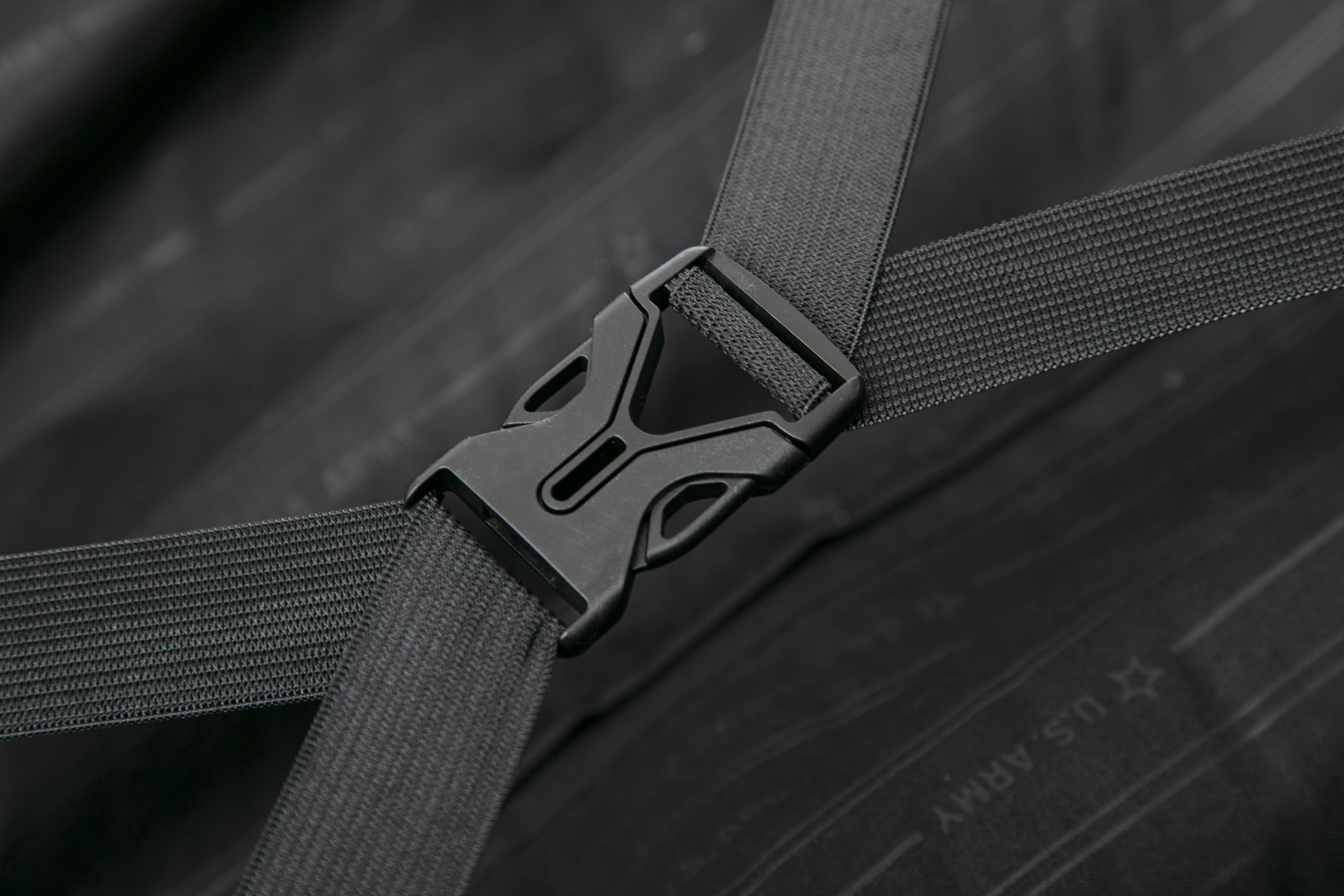 Close-up of a black seat belt buckle on a dark wooden surface