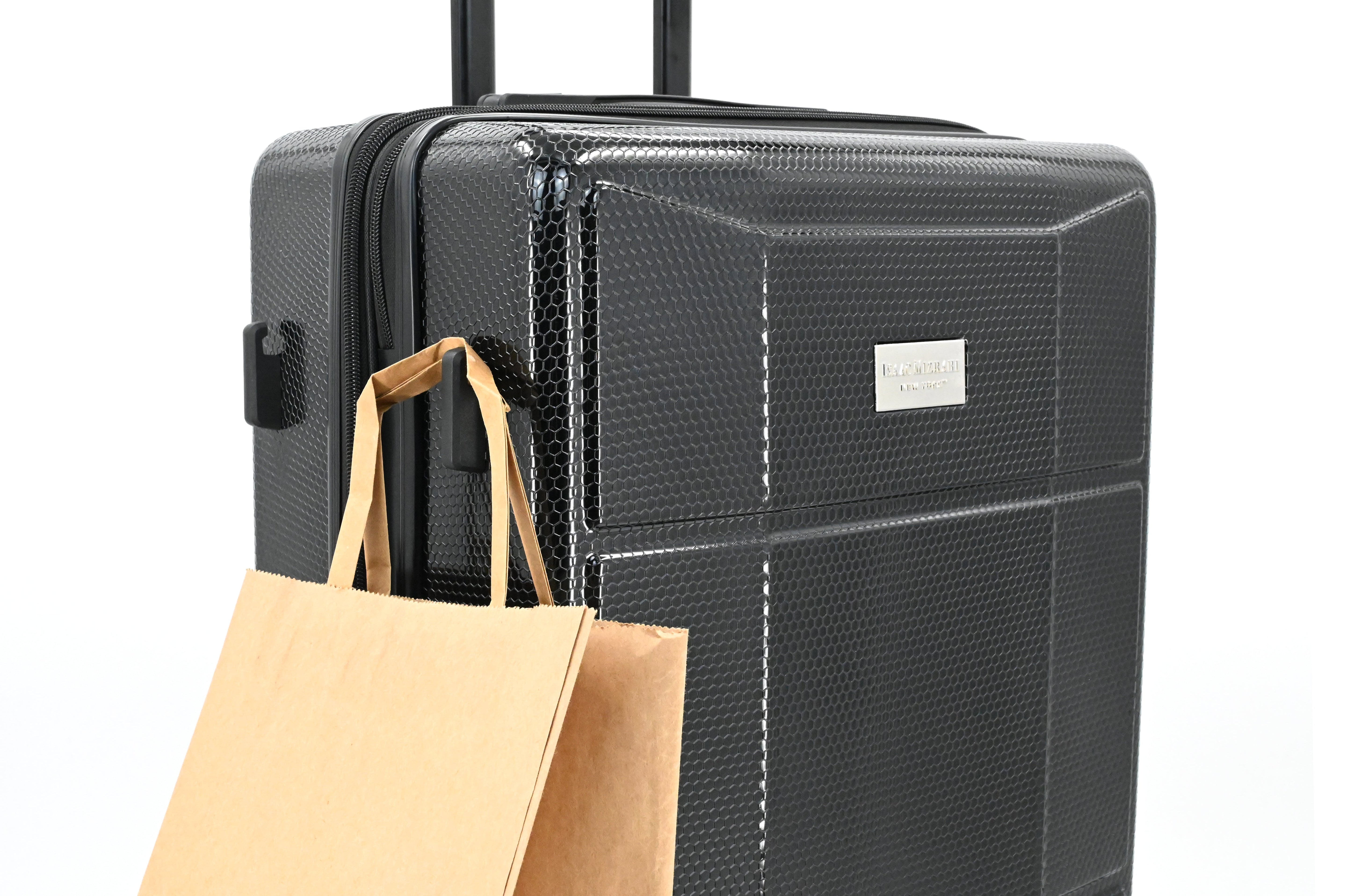 Black suitcase with a brown paper bag on a white background