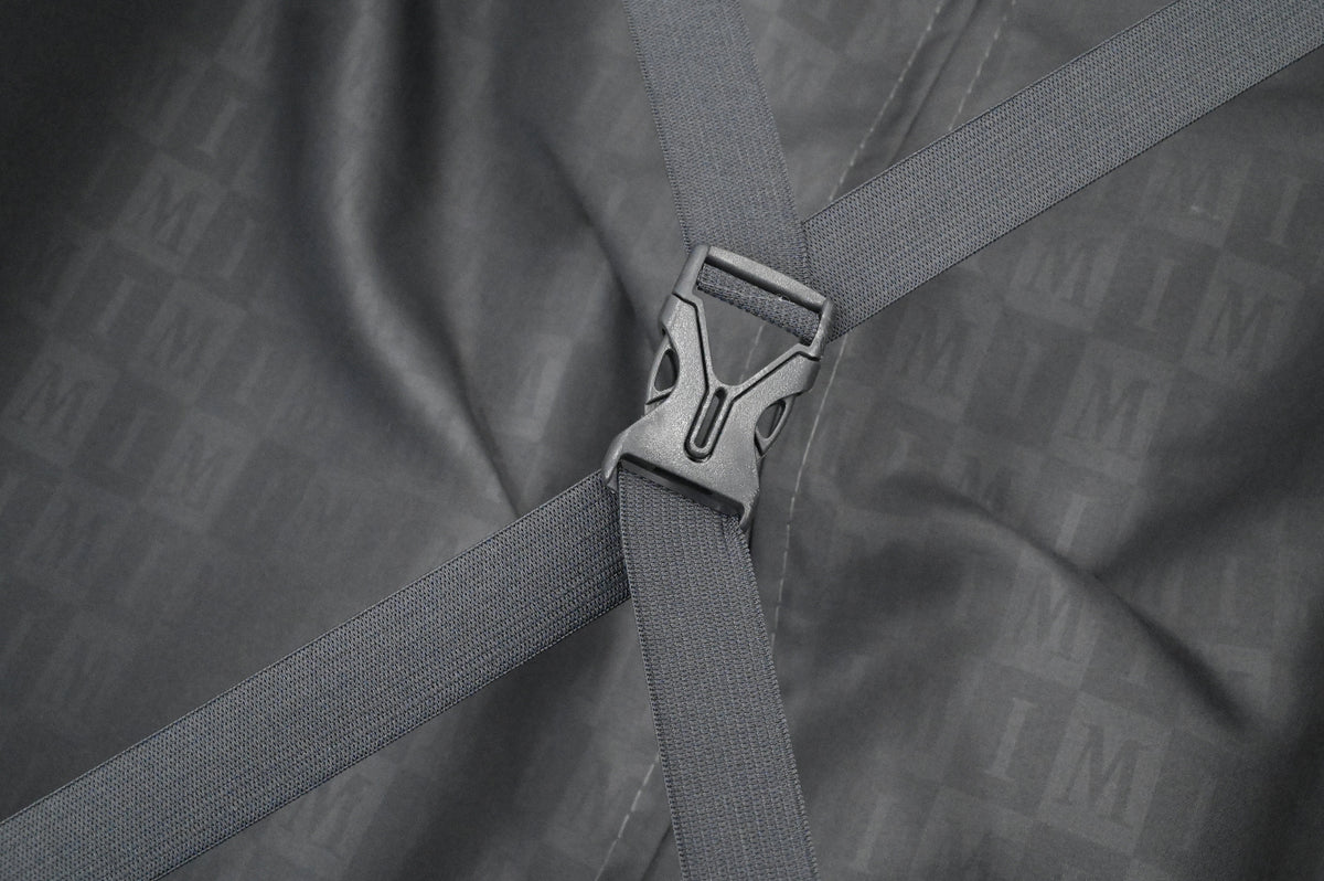 Close-up of a gray bag with a buckle on a textured gray background