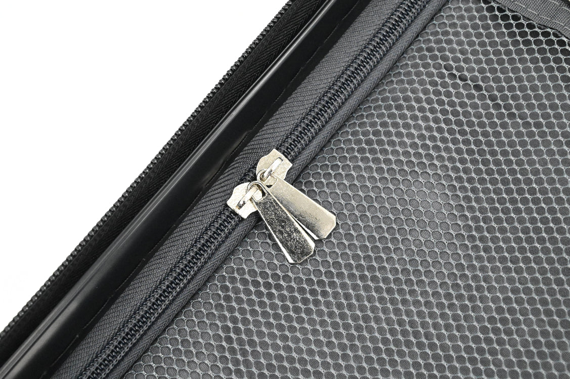 Close-up of a black textured suitcase with a silver zipper pull on a white background