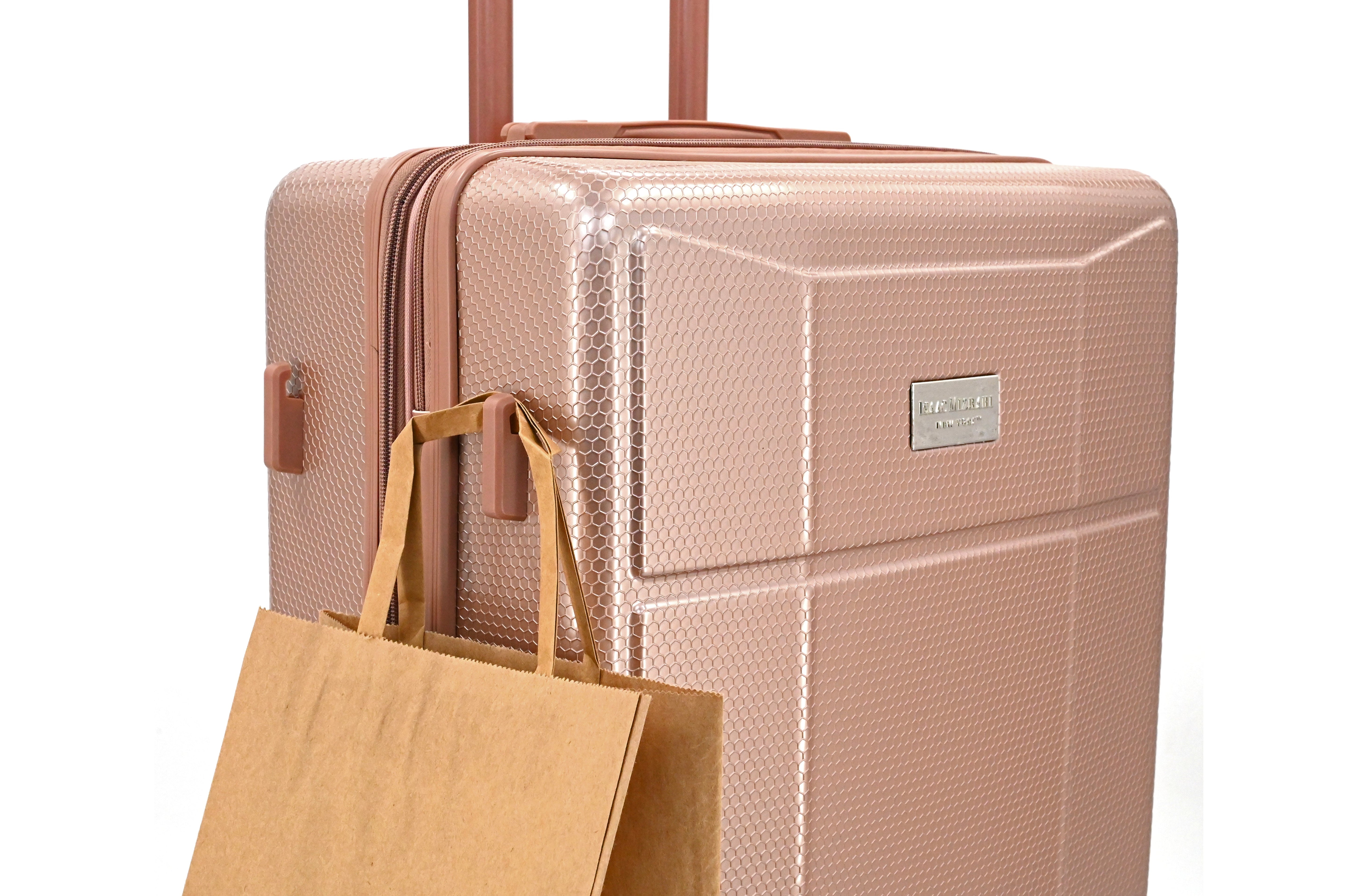 Rose gold suitcase with a brown tote bag on a white background