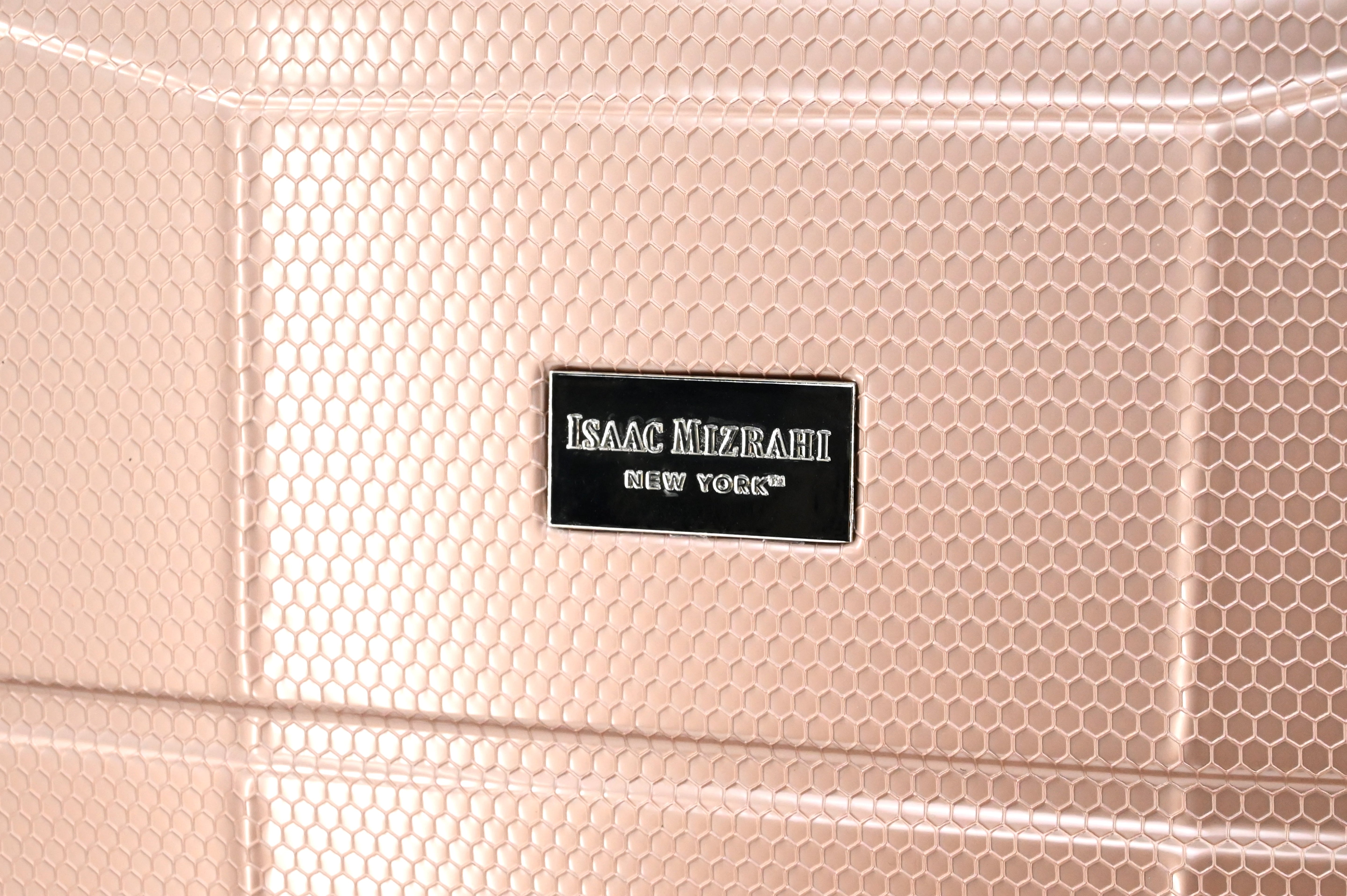 Close-up of a pink textured surface with an Isaac Mizrahi New York label.