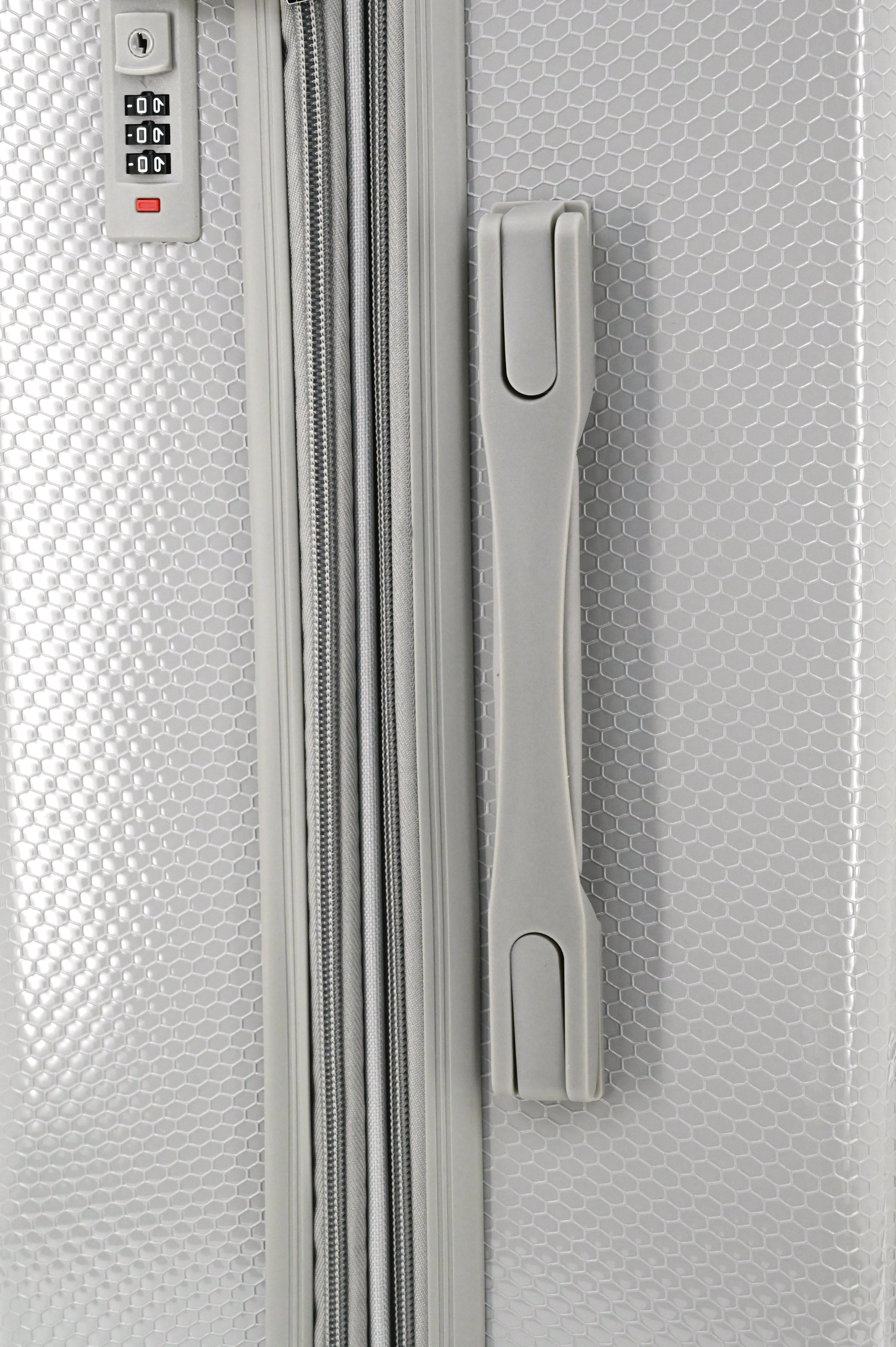 Close-up of a silver suitcase with a combination lock and handle.