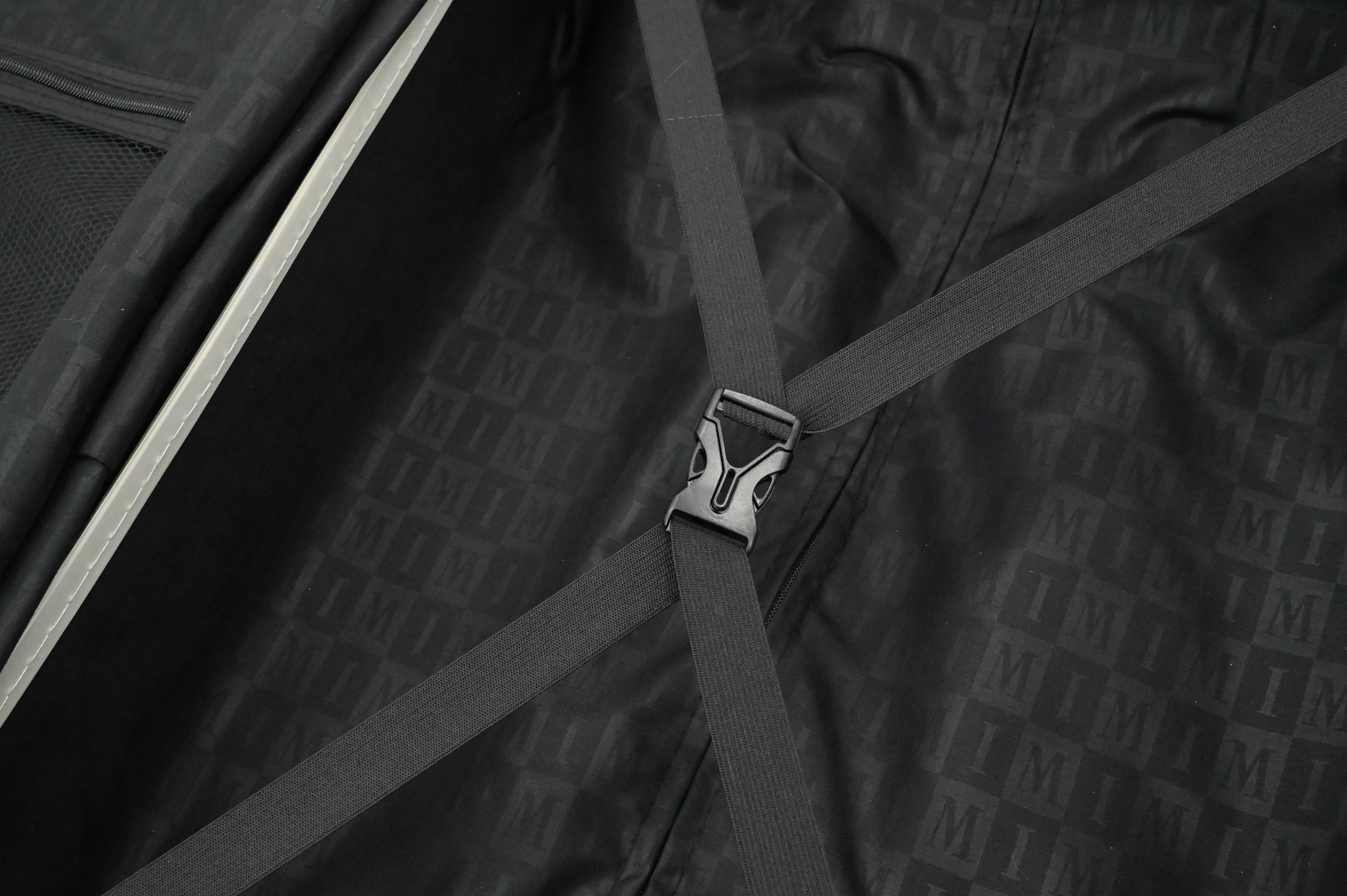 Close-up of a black suitcase with a patterned texture and a visible brand logo.