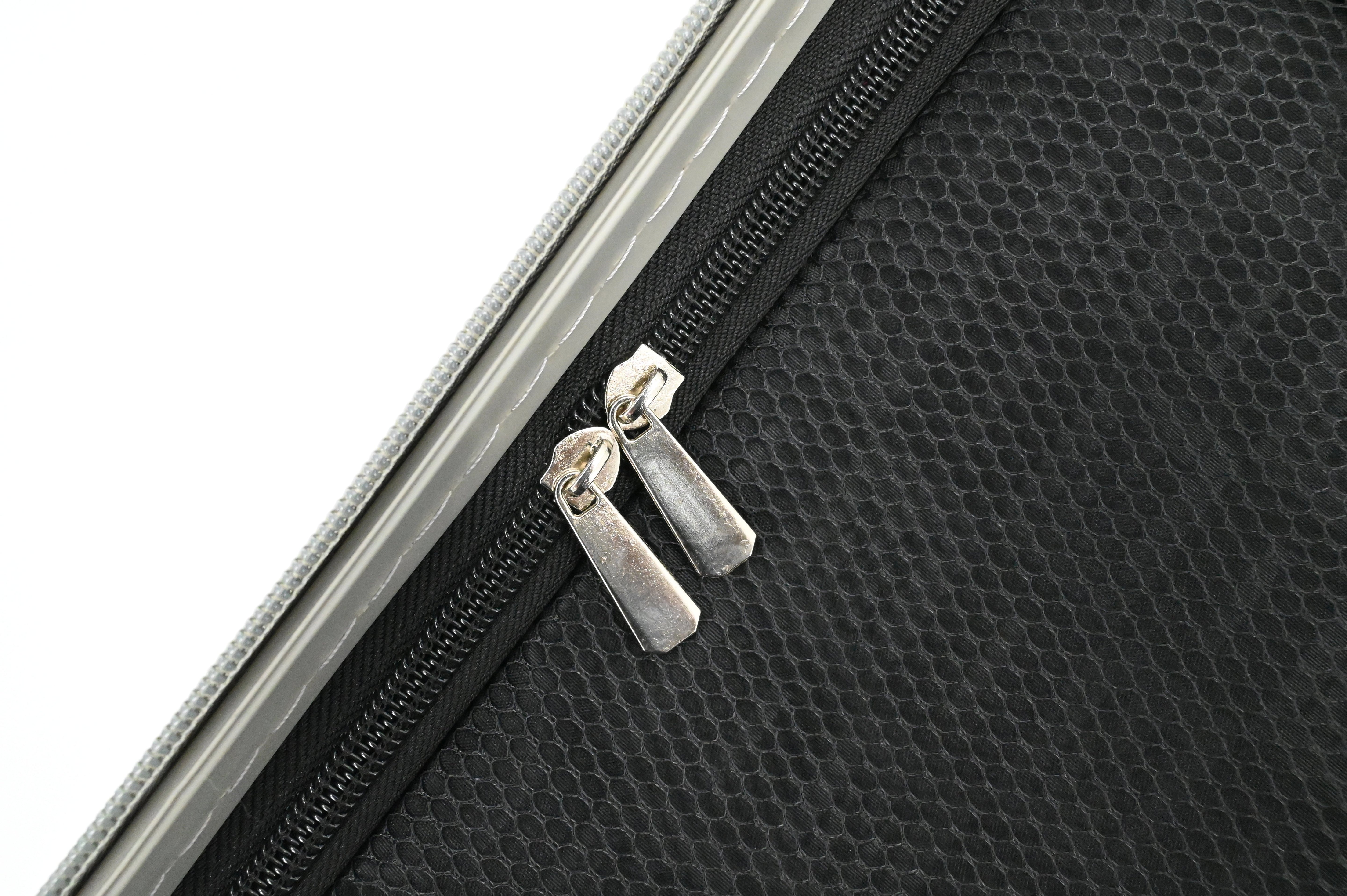 Close-up of a black textured bag with a silver zipper