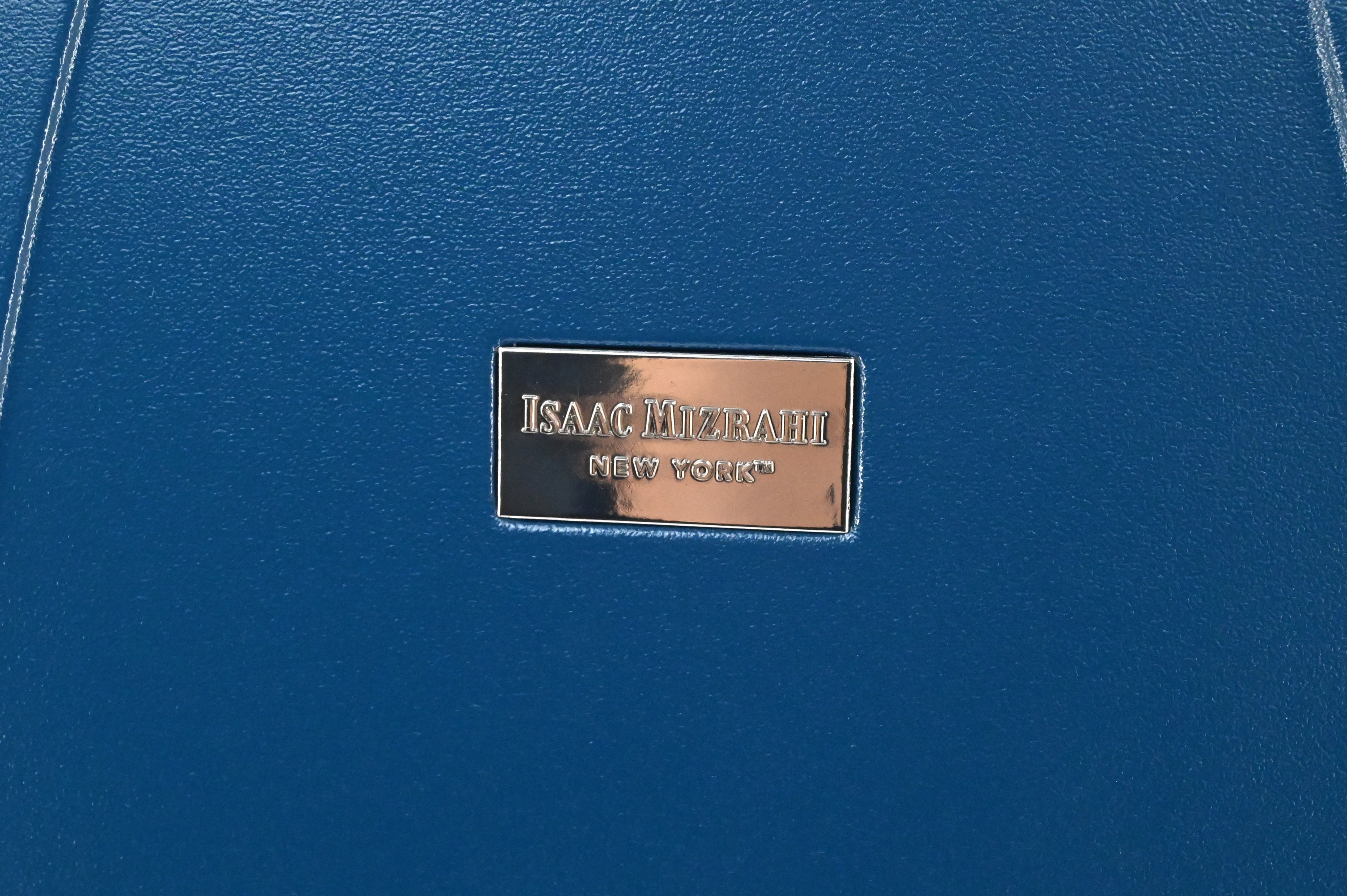 Close-up of a blue leather product with 'Isaac Mizrahi New York' label.