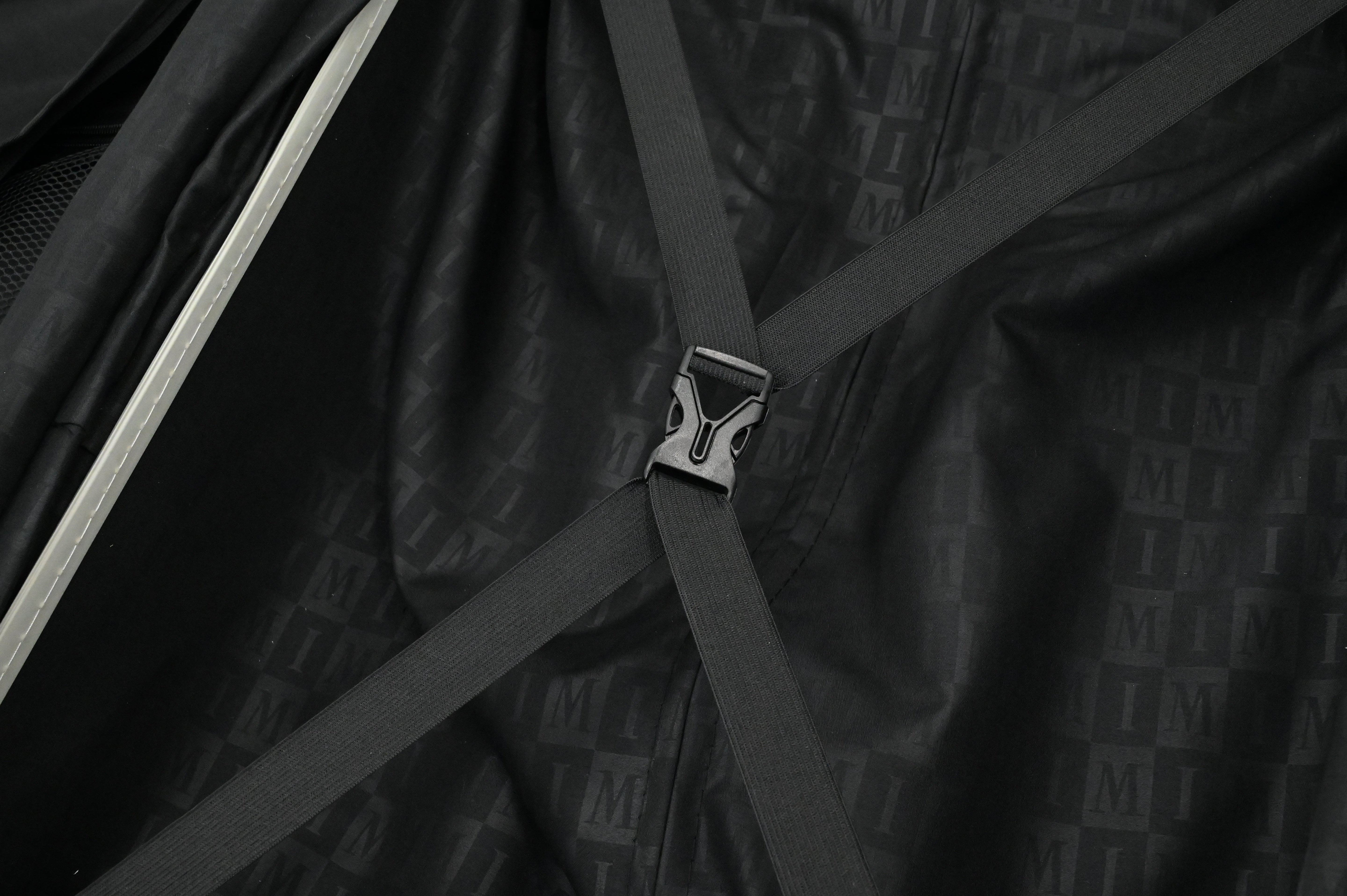 Close-up of a black bag with straps and a visible brand logo.